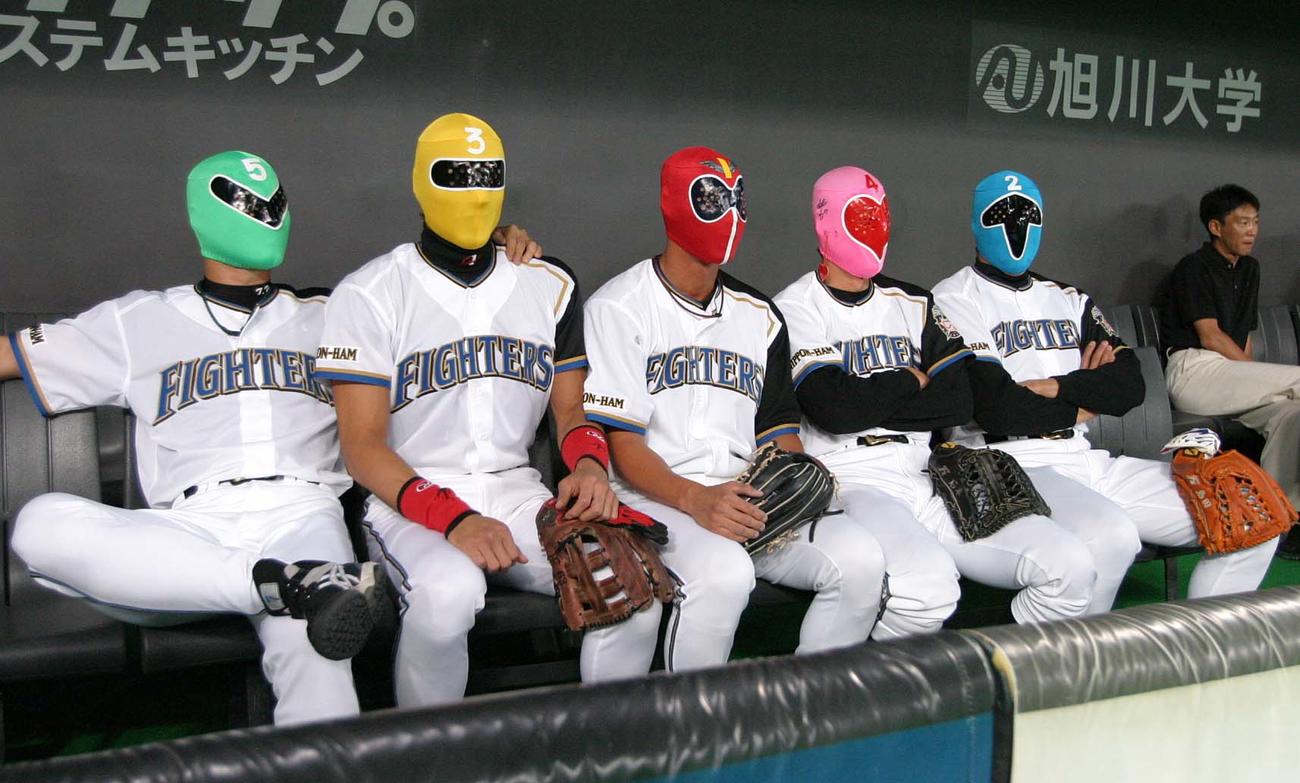 04年9月、ゴレンジャーのかぶり物でベンチに座る新庄（左から2人目）ら日本ハムの選手たち