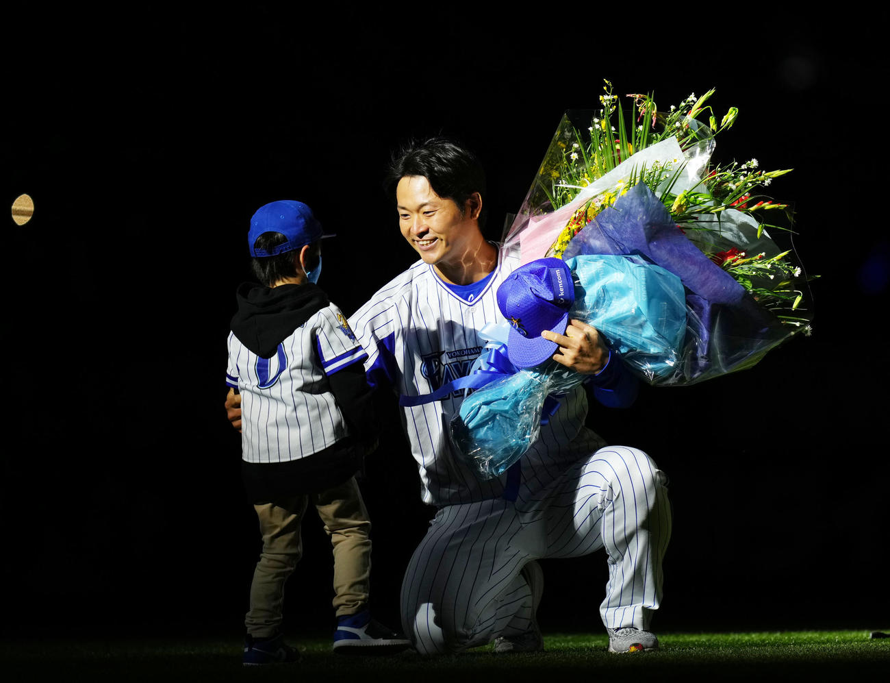 20日、引退セレモニーで息子を抱き寄せるDeNA中井