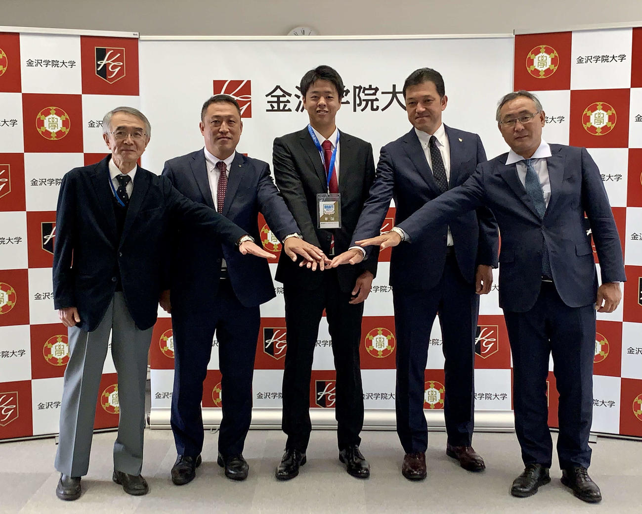 楽天ドラフト3位の金沢学院大・松井（中央）は指名あいさつを終え記念撮影をする。左から金沢学院大・藤原野球部長、同角尾監督、1人おいて楽天山田スカウト、後関スカウト部長（球団提供）