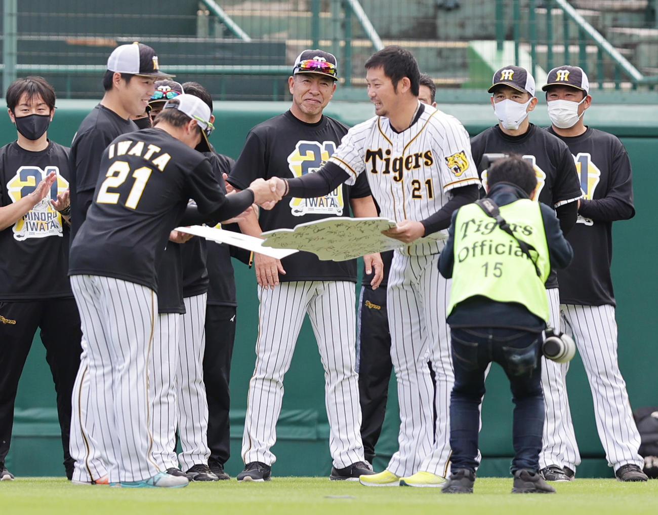 阪神対中日　練習前に梅野（左手前）、馬場（左奥）から記念品を贈られる阪神岩田稔（撮影・清水貴仁）