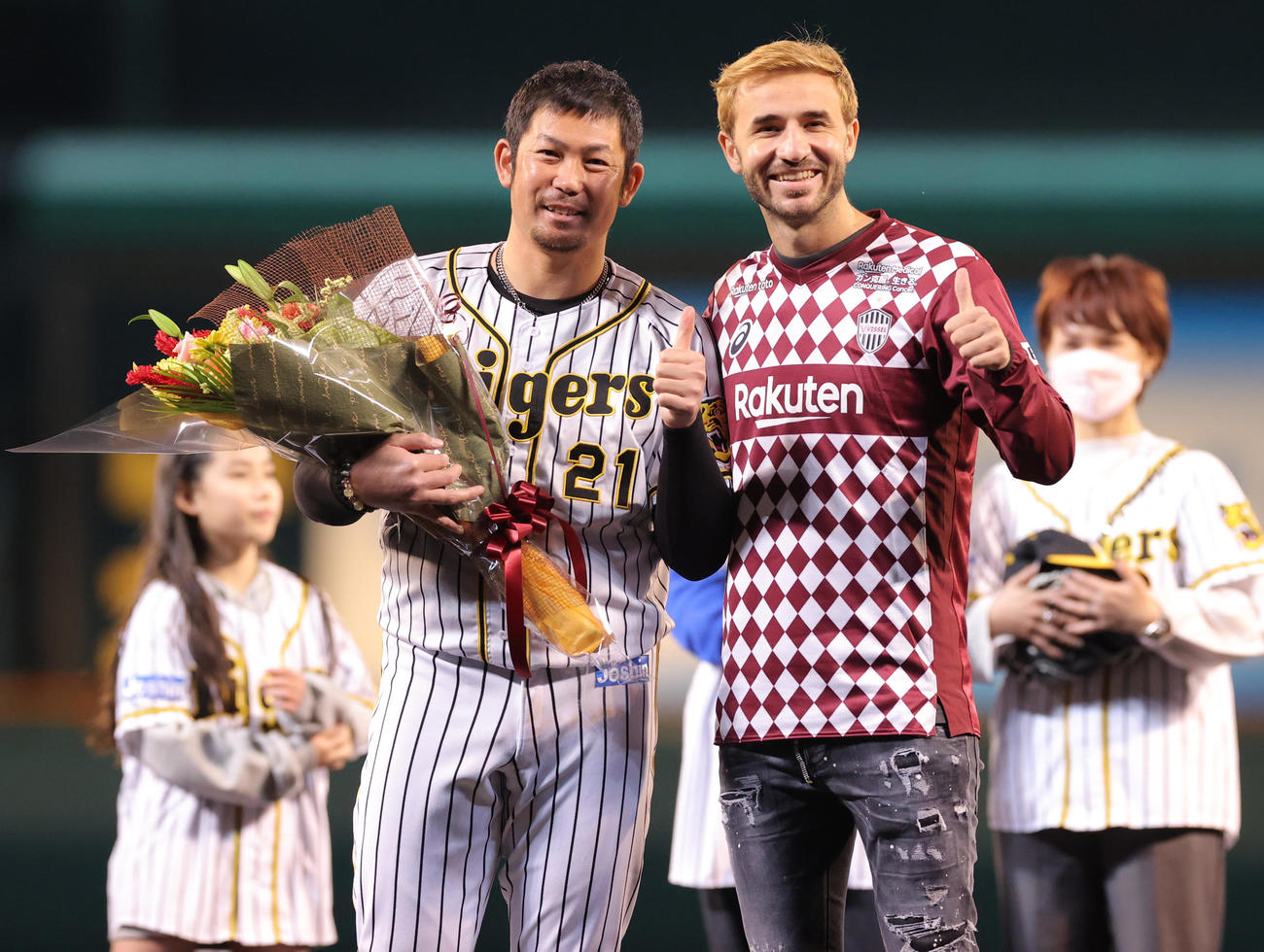阪神対中日　ファーストピッチセレモニーでヴィッセル神戸サンペール（右）から花束を受け取る阪神岩田稔
