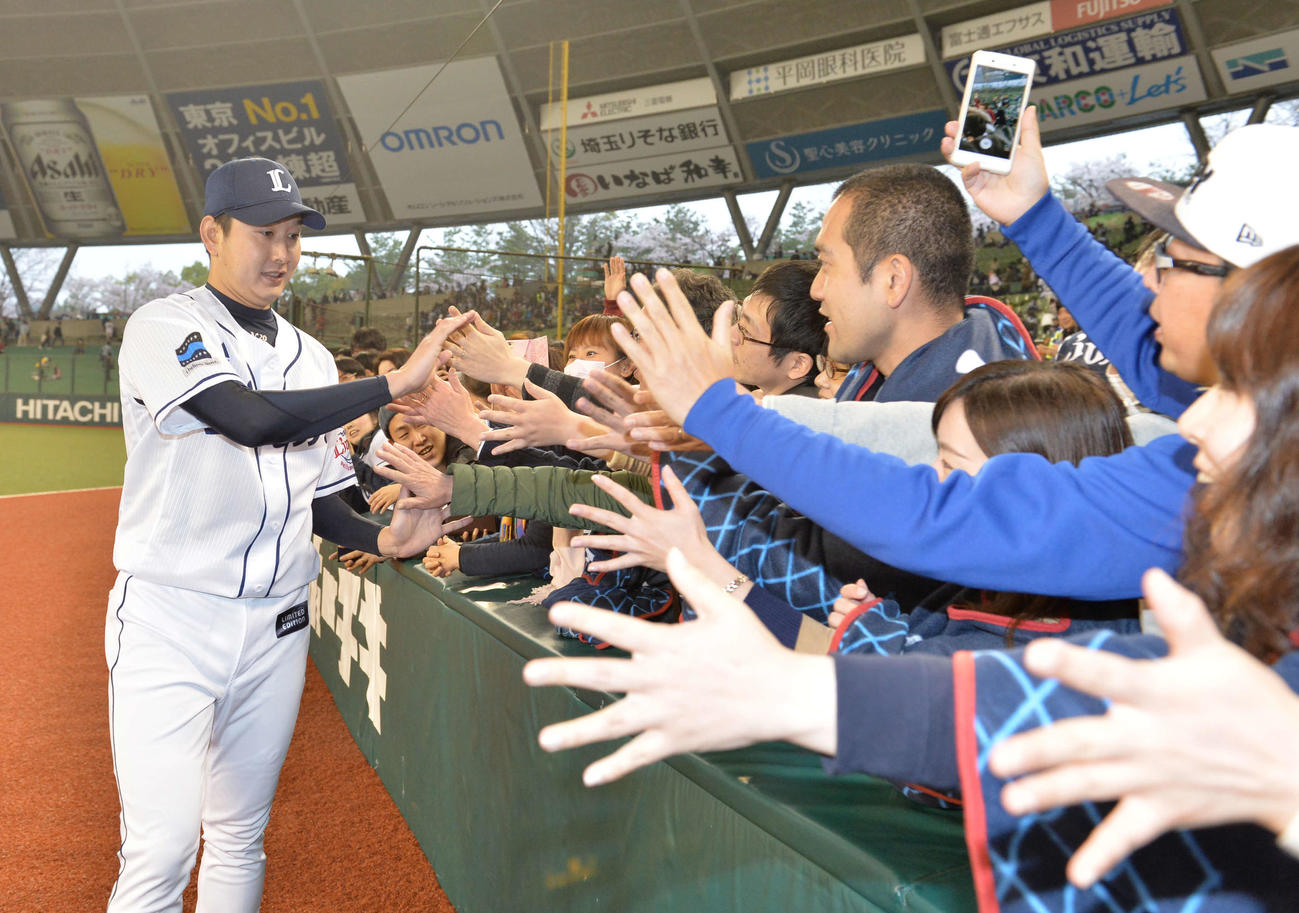 西武対ソフトバンク　今季初勝利の西武野上（左）はファンとハイタッチする（2017年4月8日撮影）
