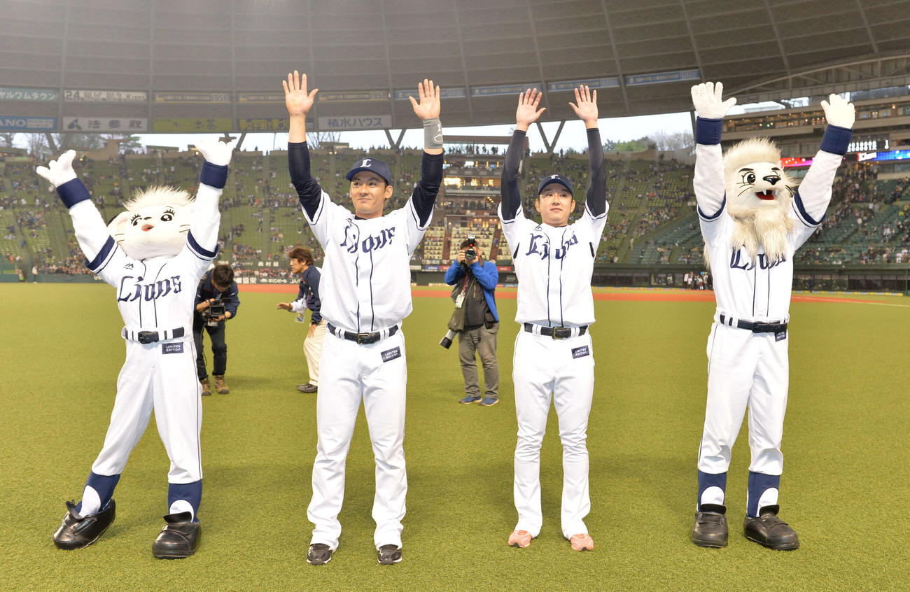 西武対ソフトバンク　ファンの前でバンザイする西武野上（中央左）と栗山（同右）（2017年4月8日撮影）