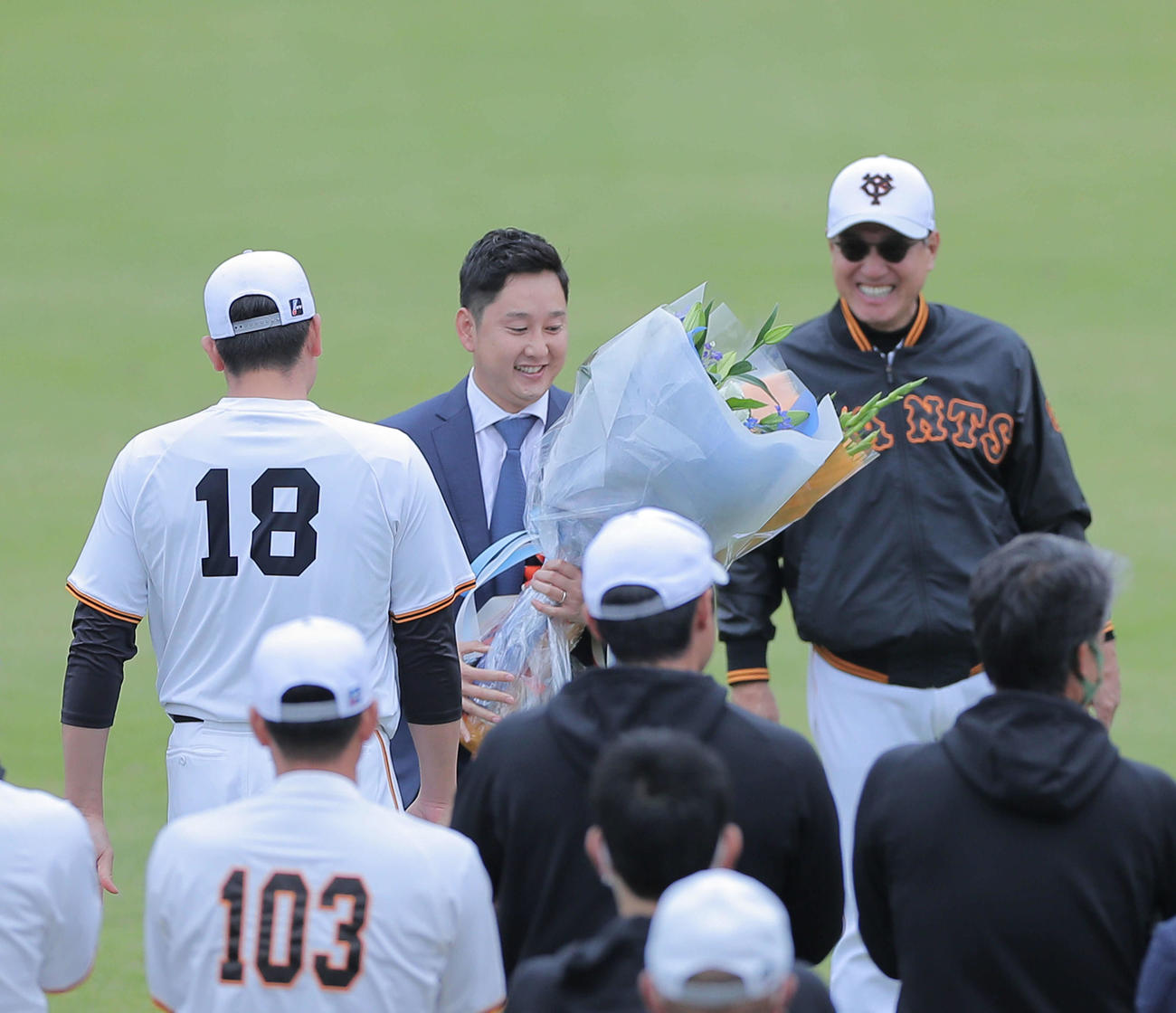 引退会見前にグラウンドで菅野（左）から花束を受け取る巨人野上。右は原監督（撮影・河田真司）