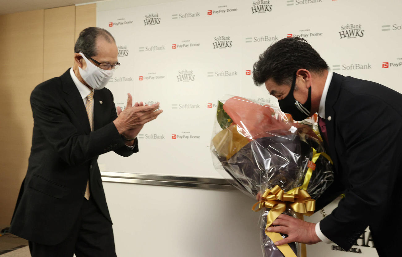 退任会見でソフトバンク王球団会長（左）から花束を贈られる前監督の工藤氏