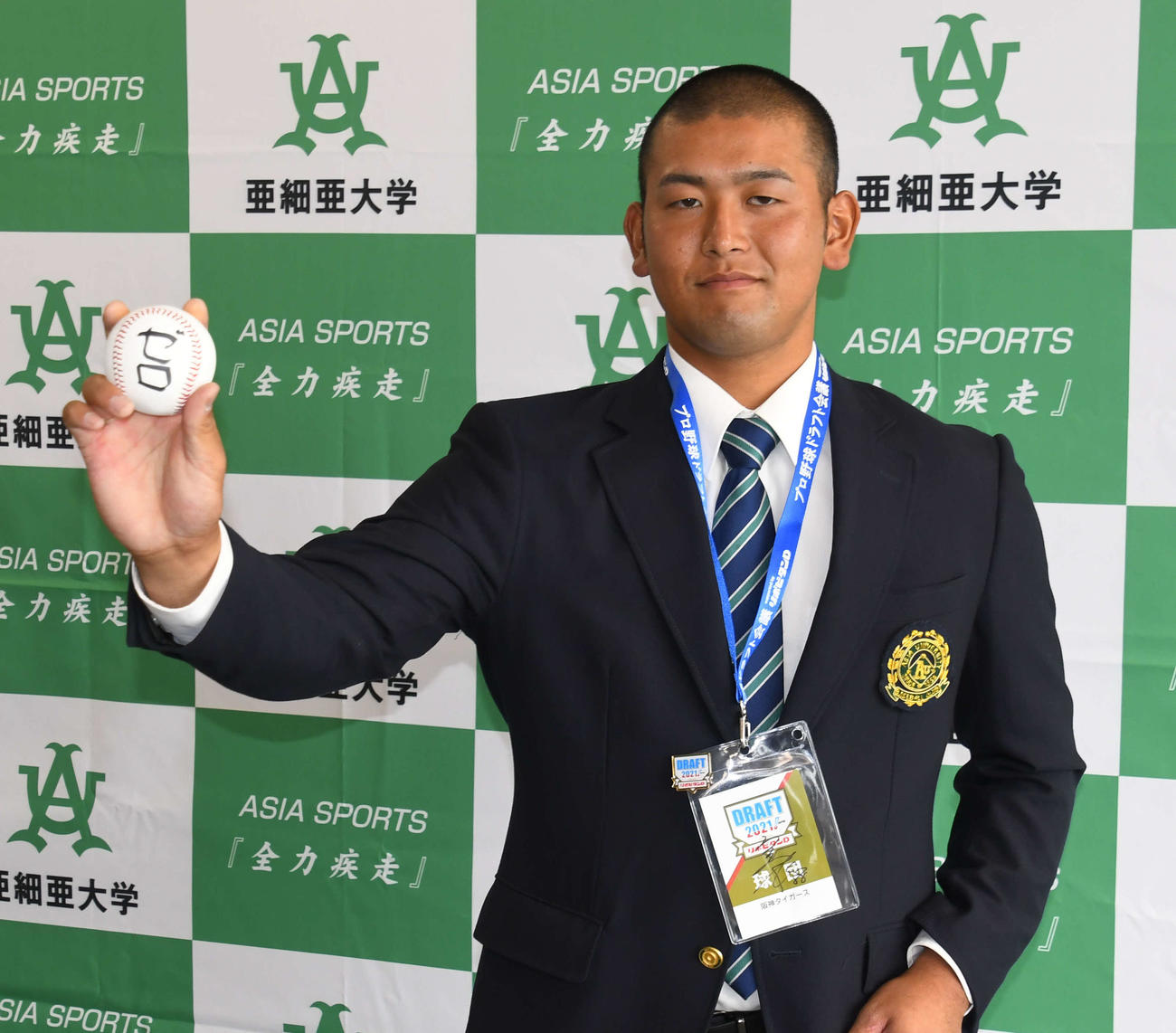 阪神にドラフト5位指名された亜大・岡留は指名あいさつを終え、「ゼロ」と書いたボールを握る（撮影・中野椋）
