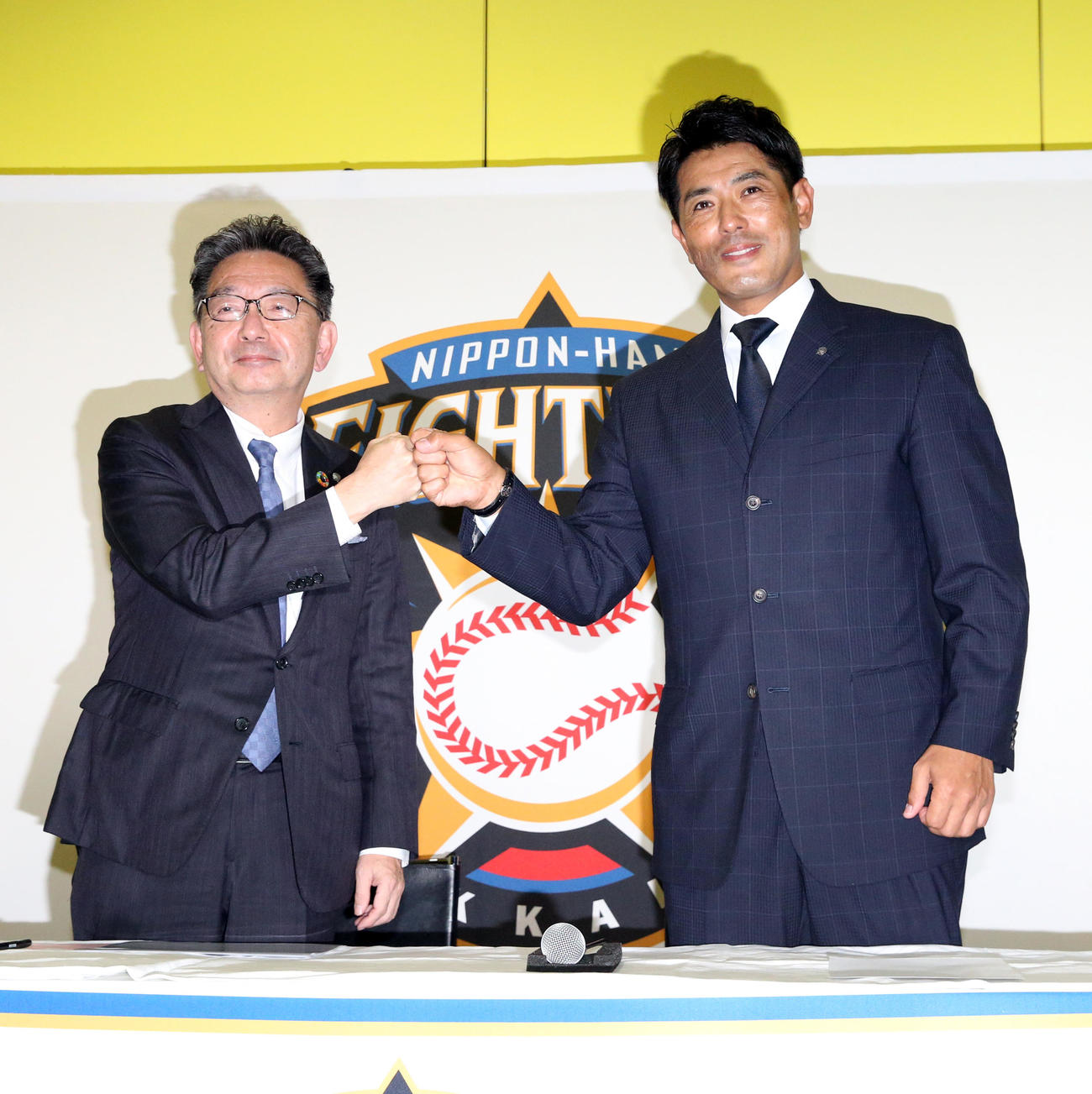 GM就任会見でグータッチを交わす日本ハム川村球団社長（左）と稲葉GM兼SCO（撮影・佐藤翔太）