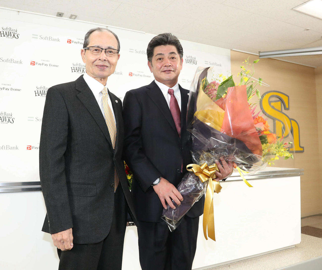 退任会見でソフトバンク王球団会長（左）から花束を贈られる前監督の工藤氏