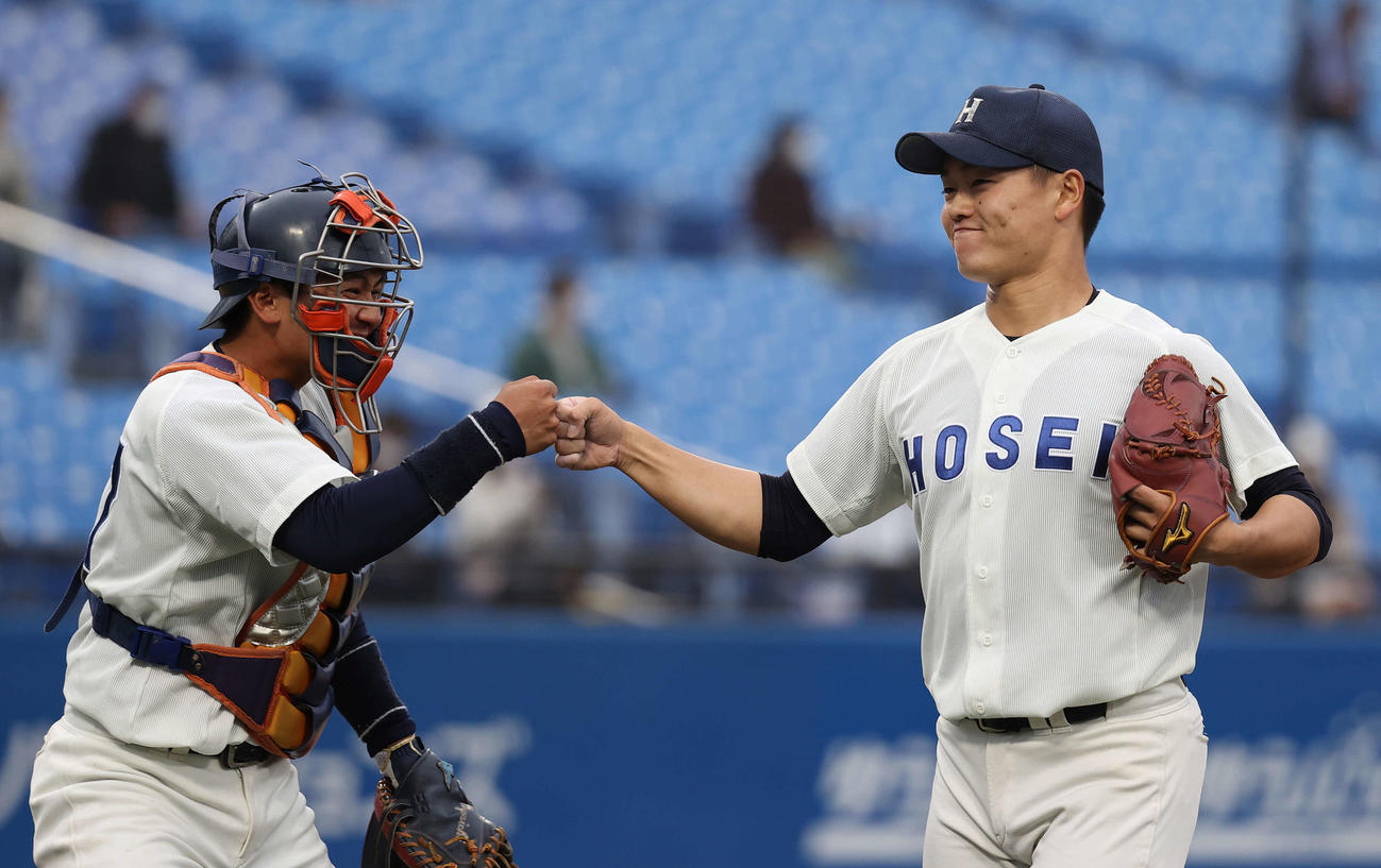 明大対法大　8回表明大2死、岩田を見逃し三振に仕留めた三浦（右）は村上とグータッチを交わす（撮影・河野匠）