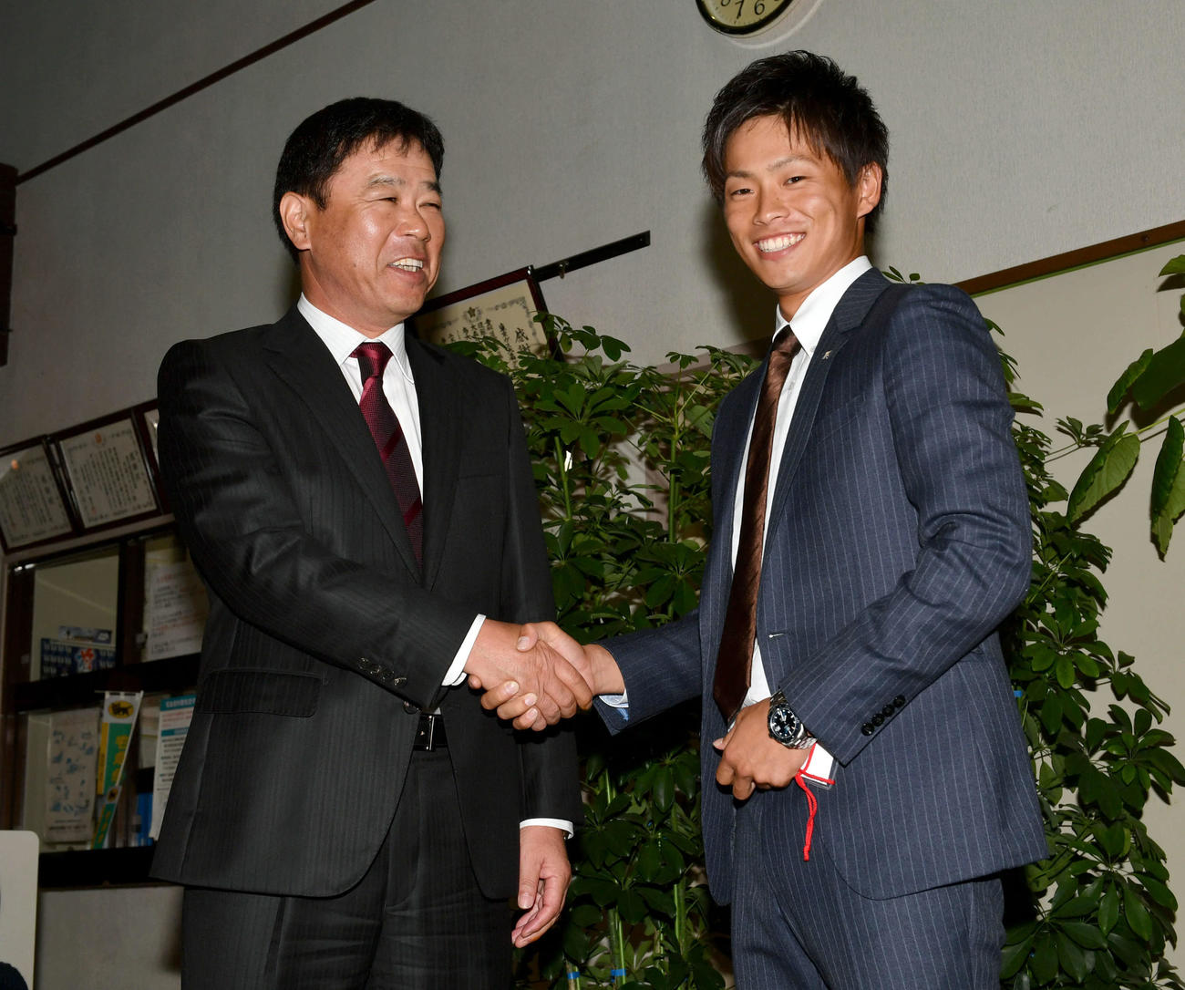 2016年10月20日、オリックスの1位で指名された東京ガス山岡泰輔（右）は福良淳一監督と笑顔で握手を交わす