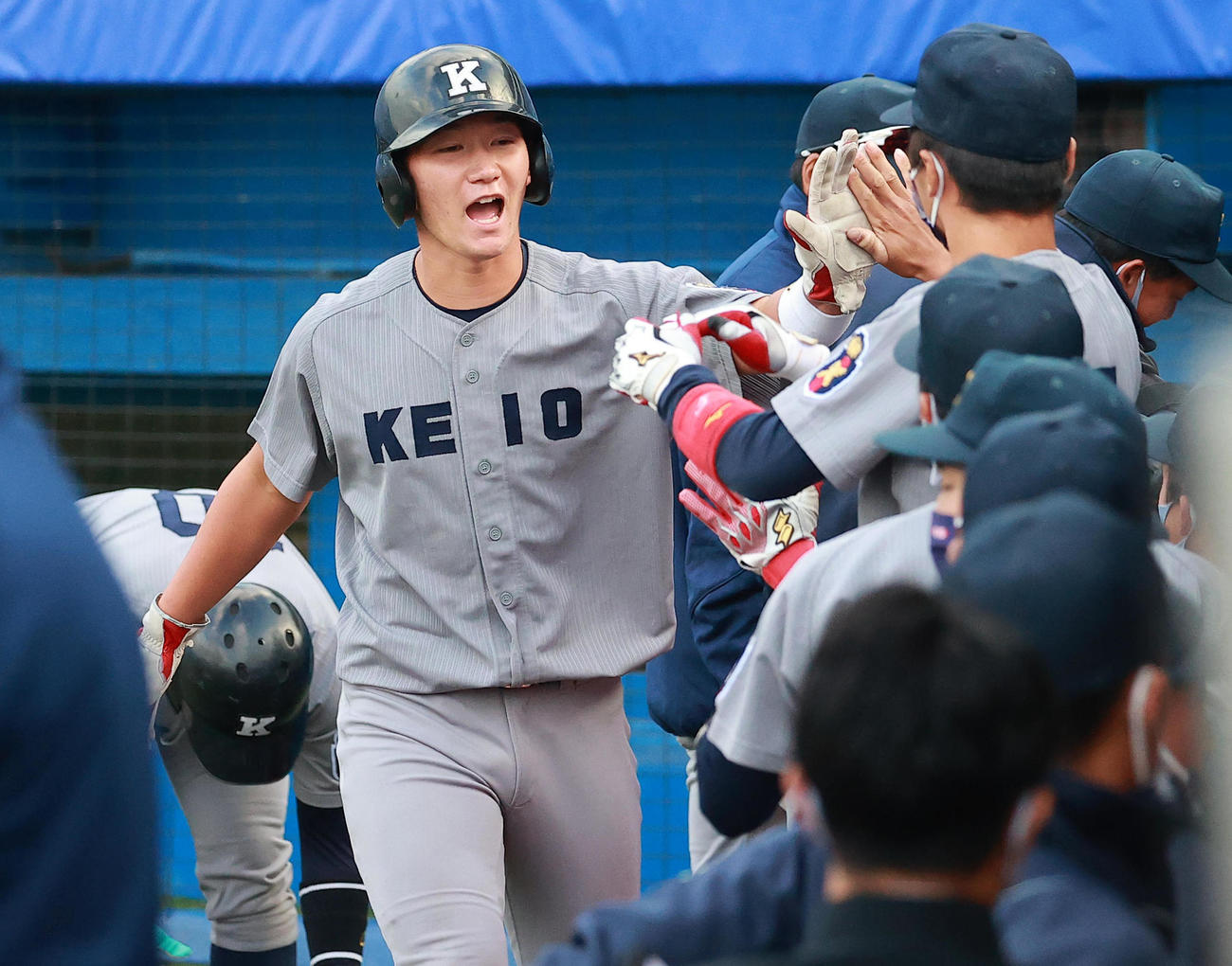 18日の立大戦で生還しベンチに迎えられる慶大・正木