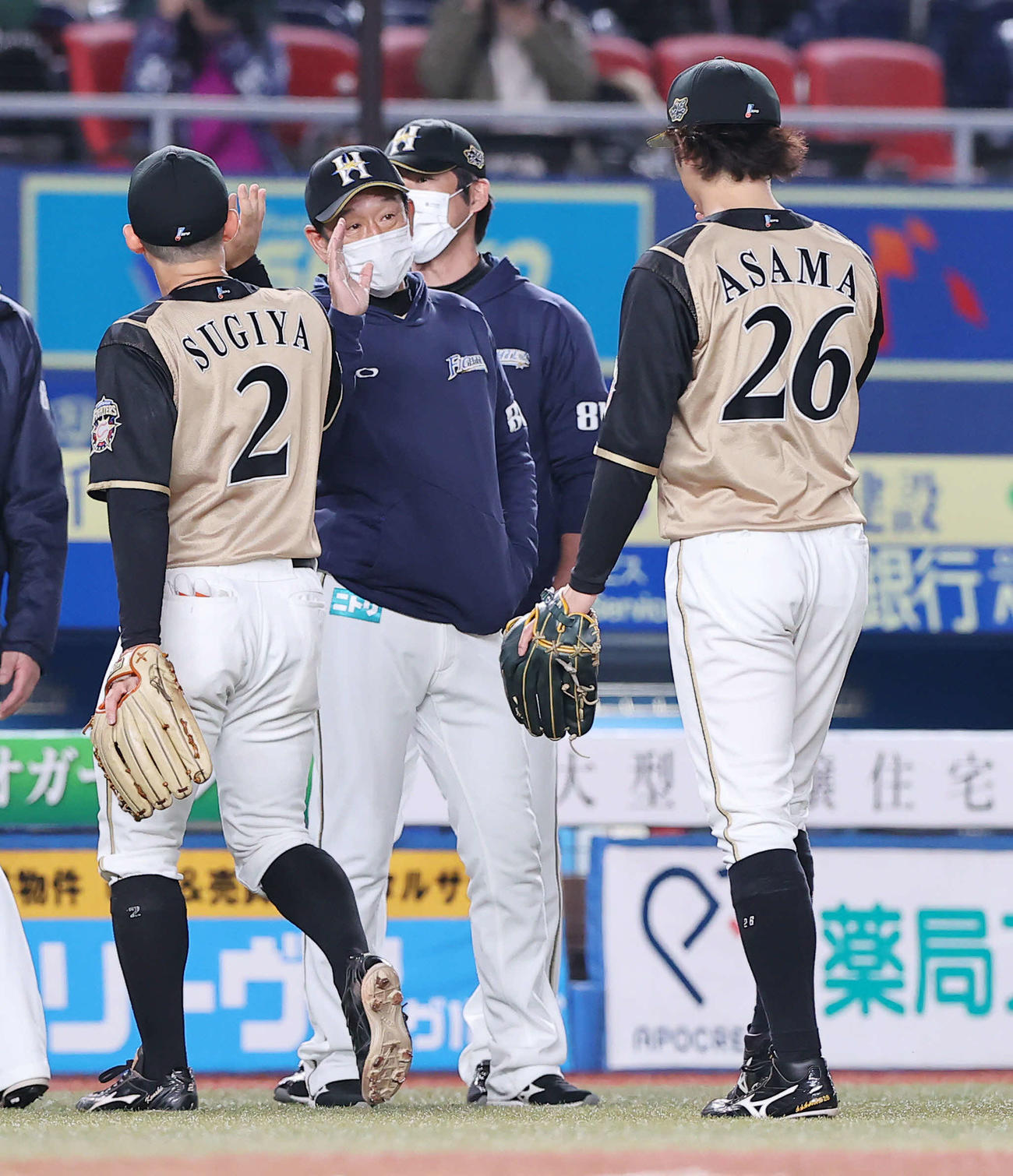 ロッテ対日本ハム　ロッテに勝利し浅間（右）らナインを出迎える日本ハム栗山監督（中央）（撮影・垰建太）