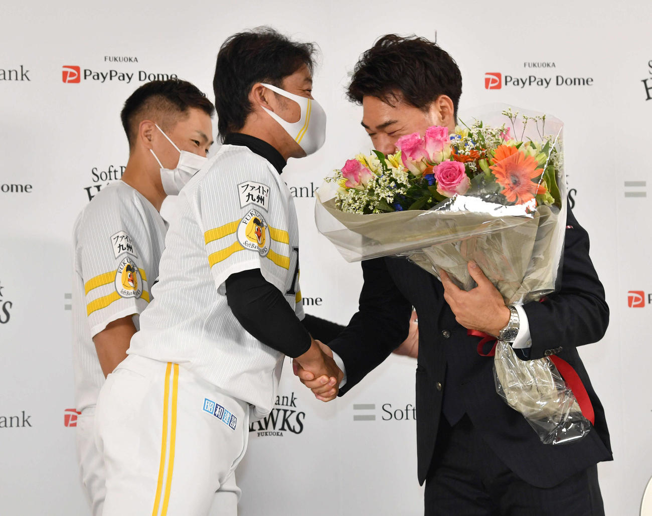 引退会見で左から中村晃、高谷裕亮から花束を受け取り、握手を交わす長谷川勇也（2021年10月9日撮影）
