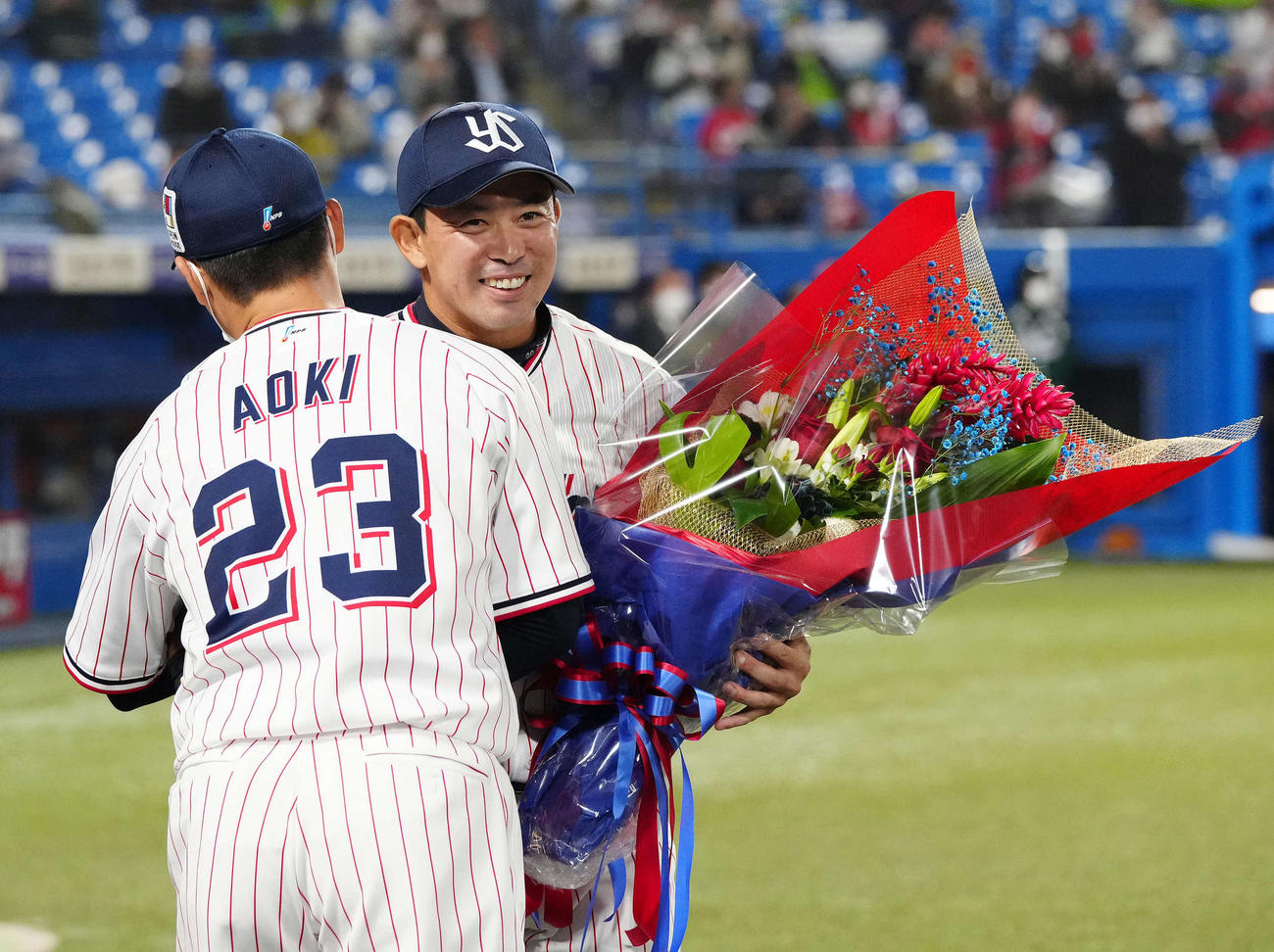 ヤクルト対広島　6回表開始前、ヤクルト青木（左）から花束を受け取る雄平（撮影・江口和貴）