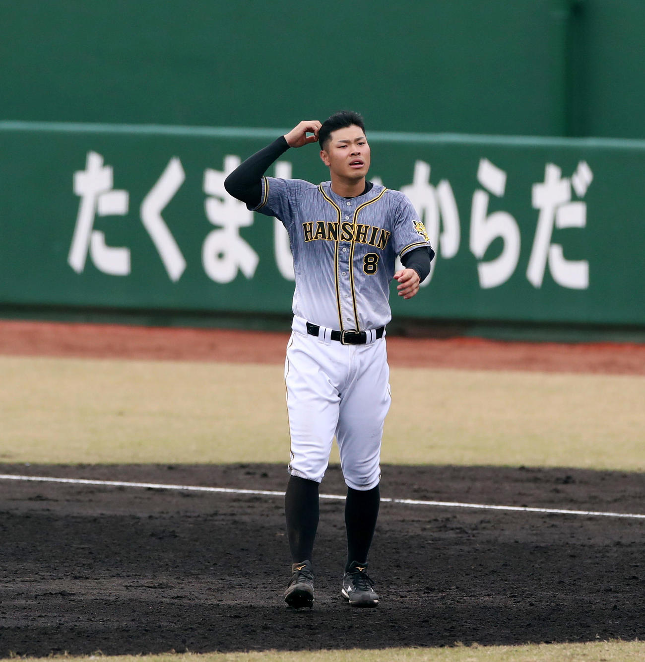フェニックス・リーグロッテ戦　9回表阪神攻撃終了、佐藤輝は「たくましいからだ」をバックに守備位置に向かう（撮影・加藤哉）