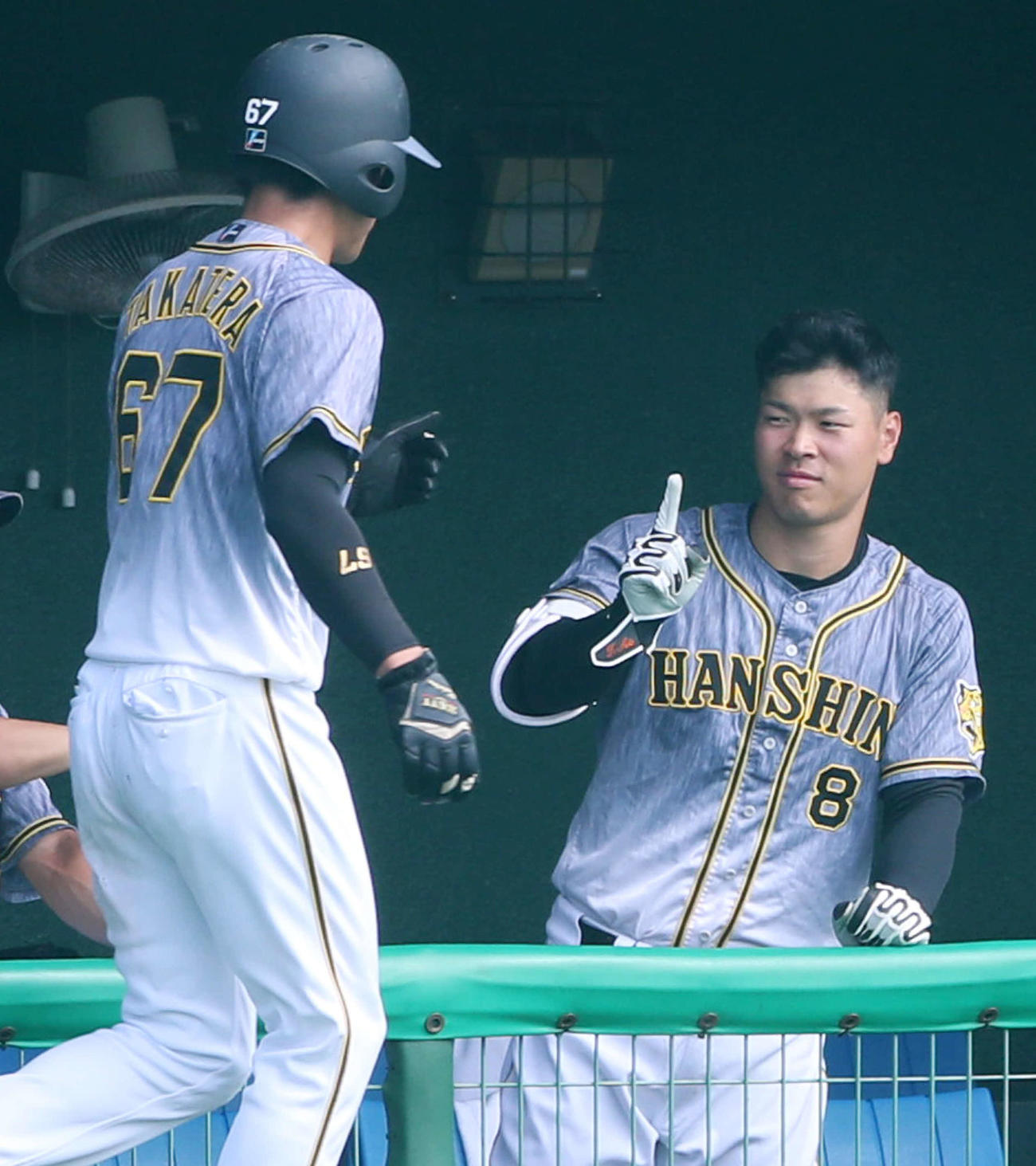 ロッテ対阪神　2回表阪神無死一、三塁、ベンチの佐藤輝（右）は、島田の右前適時打で生還した高寺を人さし指を立てて迎える（撮影・加藤哉）