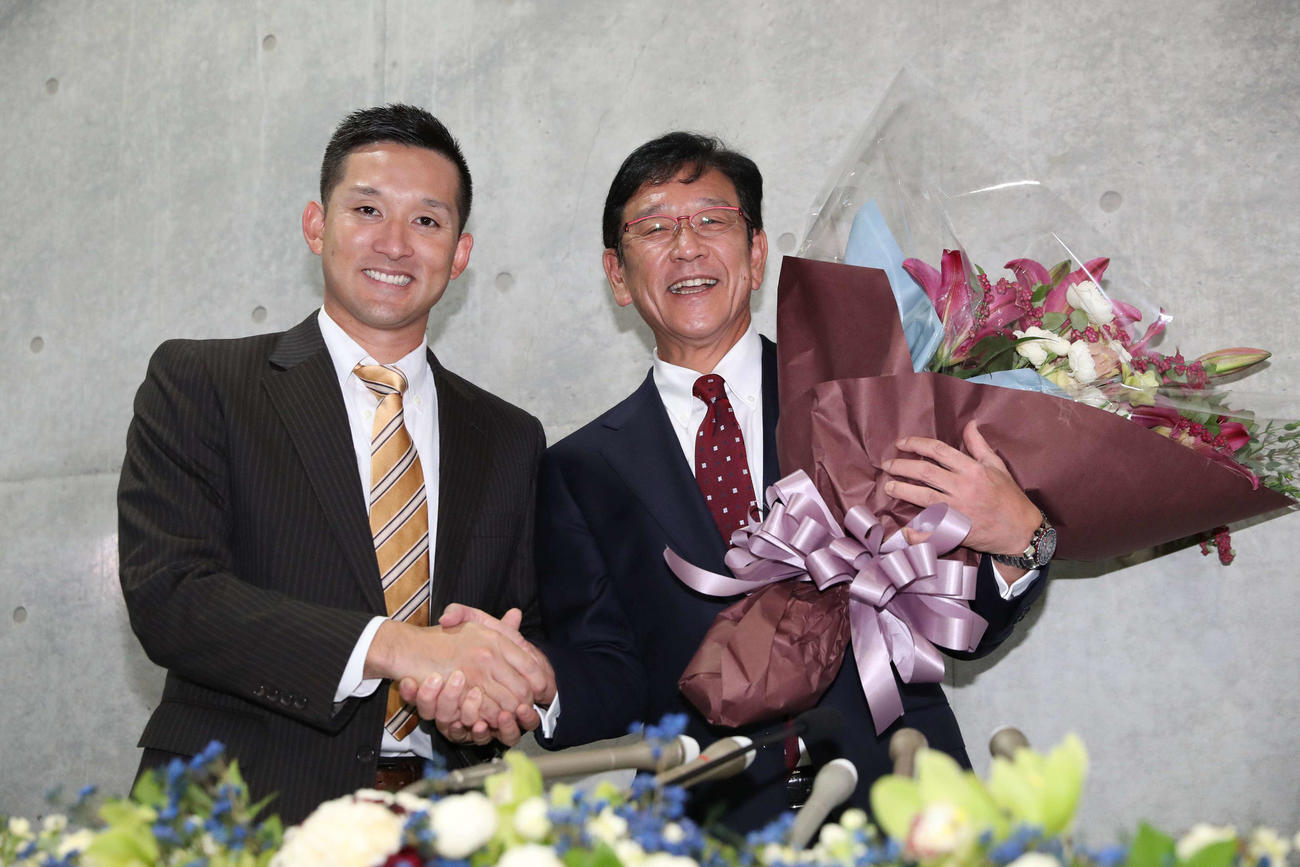 監督退任会見で飛び入りした杉谷（左）から花束を受け取る日本ハム栗山監督（2021年11月1日撮影）