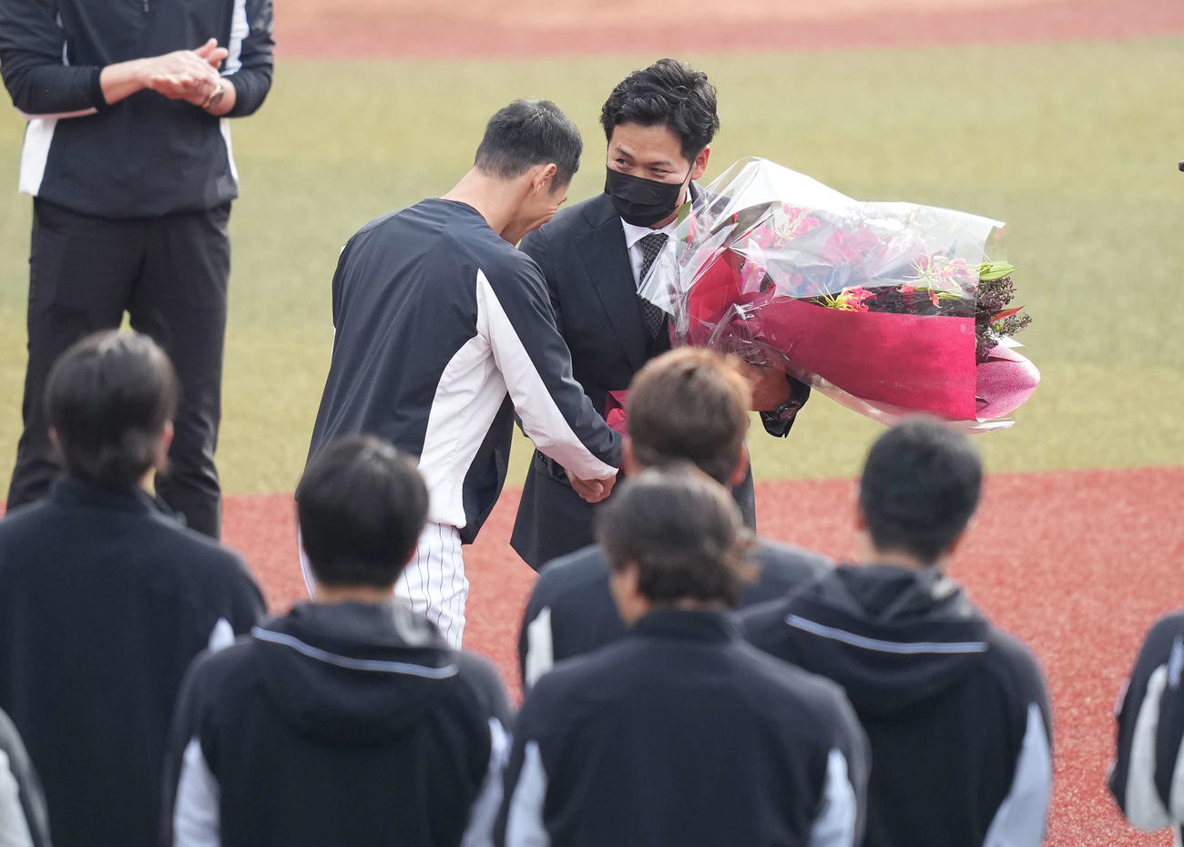 引退するロッテ小窪（右）は荻野から花束を受け取る（撮影・鈴木みどり）