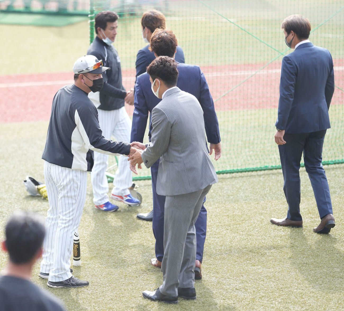 ロッテ井口監督（左）は戦力外通告を受けた永野（中央手前）らと握手（撮影・鈴木みどり）