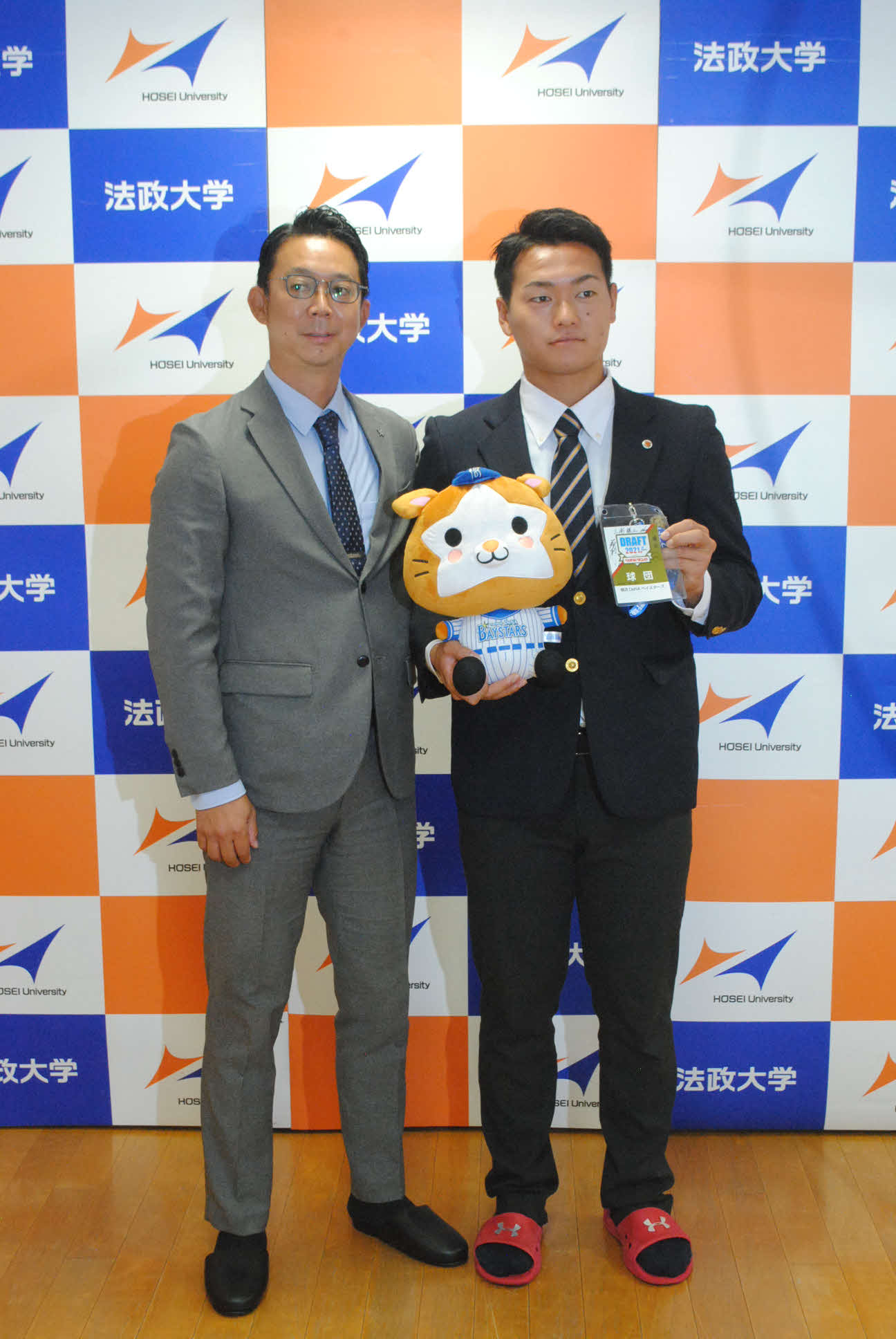 DeNAからドラフト4位指名された法大・三浦銀二投手（右）は八馬幹典スカウトの指名あいさつを受けた