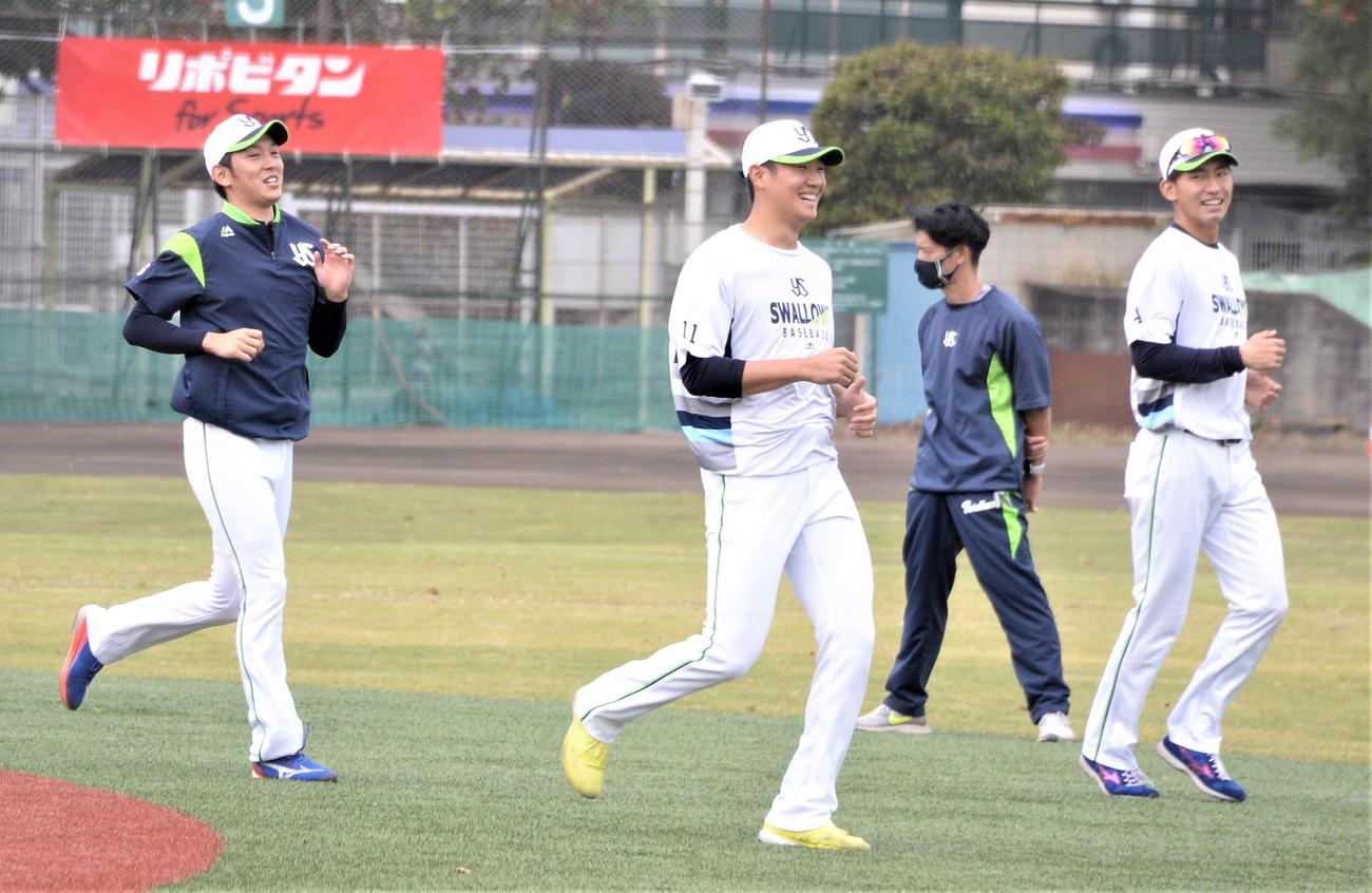 練習中にリラックスした表情を見せるヤクルト奥川（中央）。左は原、右は金久保（撮影・鈴木正章）