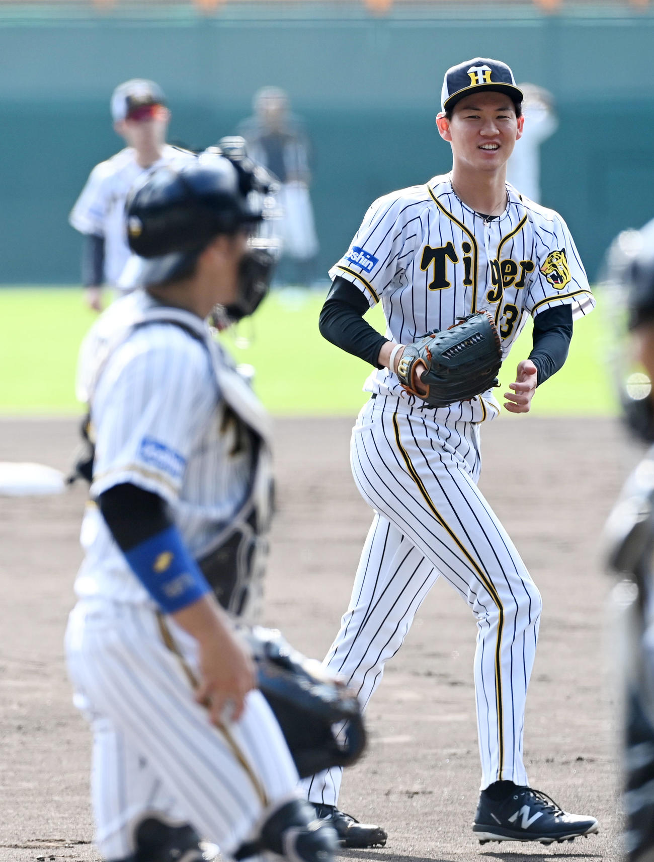 投内連係で笑顔を見せる及川（撮影・前岡正明）