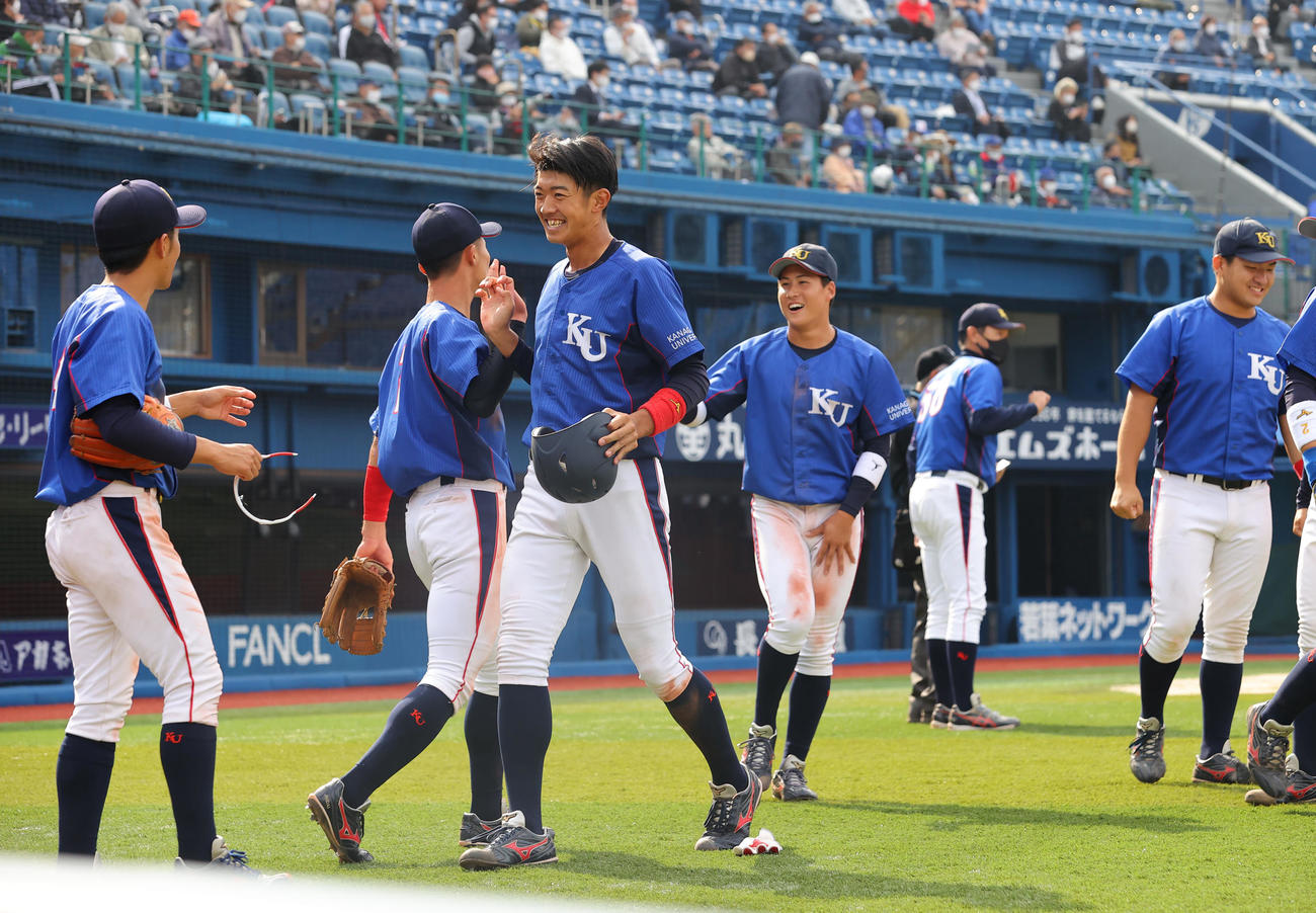 神奈川大対創価大　9回表、勝ち越しの適時二塁打を放った神奈川大・梶原（左から3人目）は笑顔でナインの出迎えを受ける（撮影・垰建太）