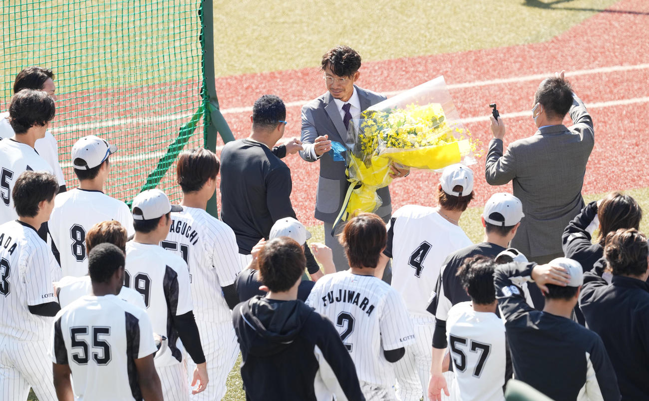スーツ姿で引退のあいさつしたロッテ鳥谷は、花束を手にナインとタッチする（撮影・菅敏）