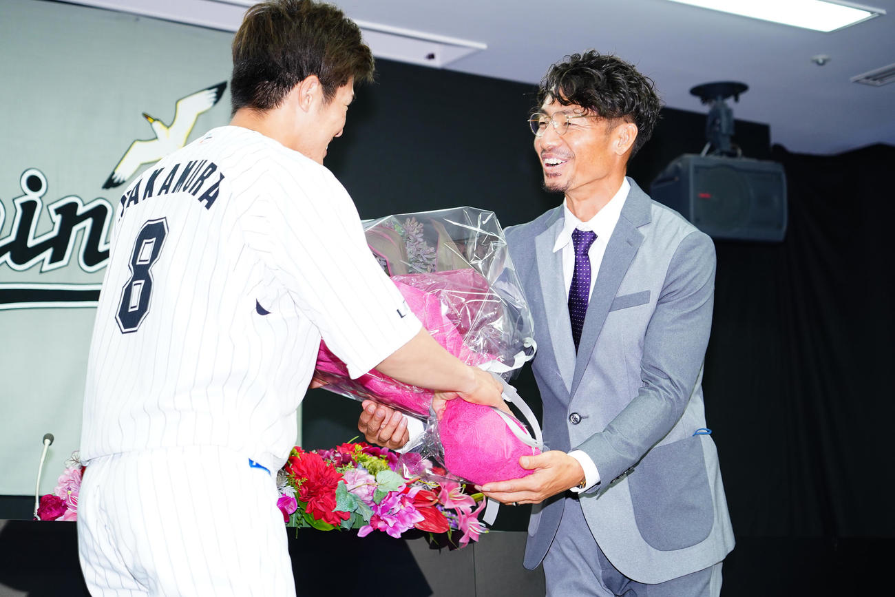 引退会見で中村奨（左）から花束を受け取るロッテ鳥谷（撮影・菅敏）