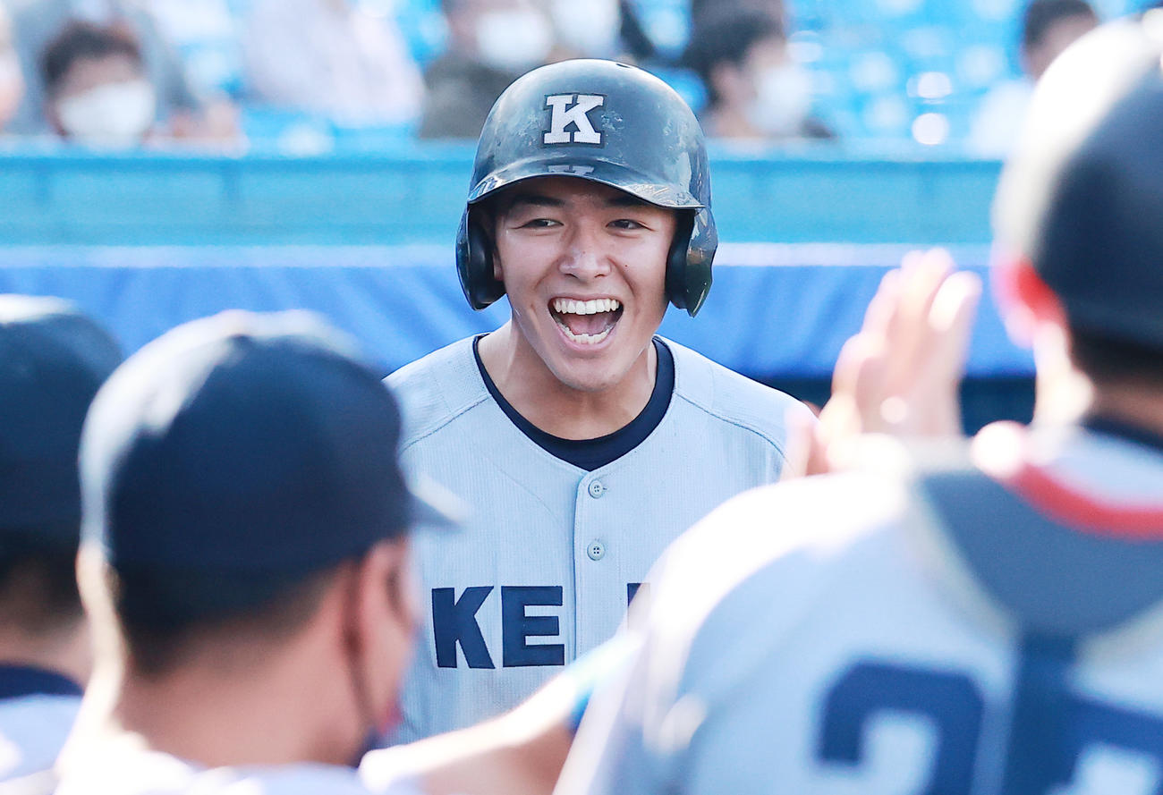 慶大対東大　4回表慶大1死満塁、小川尚人の左前先制適時打で生還しベンチに迎えられる清原（撮影・野上伸悟）