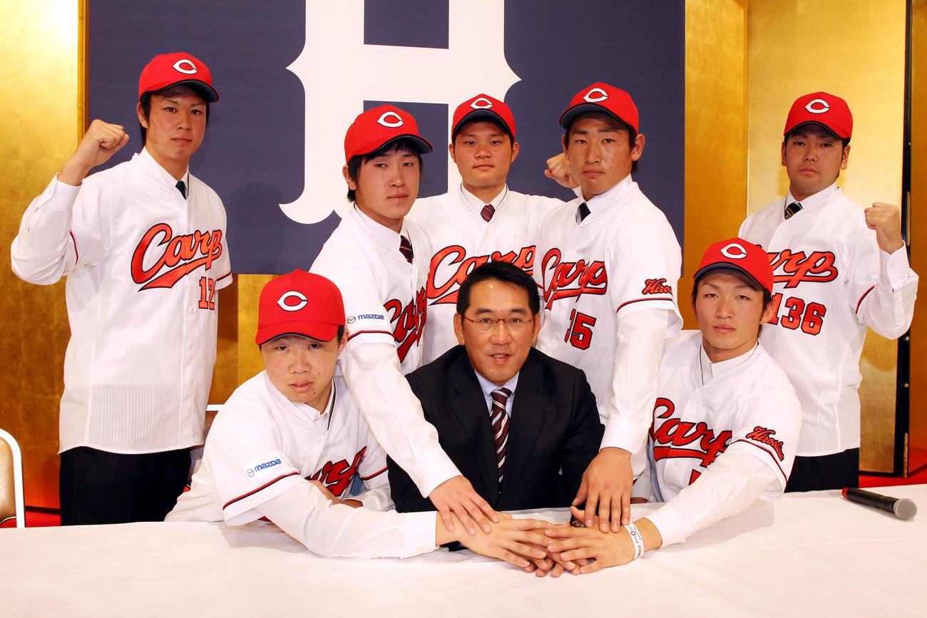 2013年度広島新人入団会見　広島新人入団会見で野村監督を中心にポーズをきめる、左から辻空、高橋、上本、美間、下水流、鈴木、森下