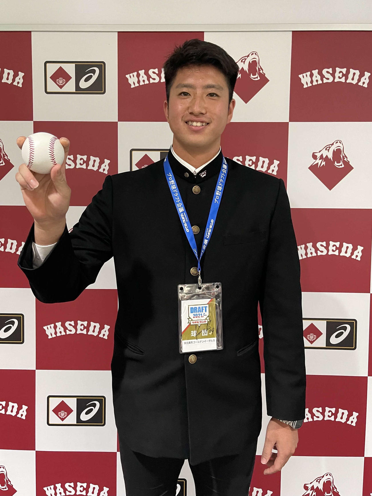 楽天ドラフト6位の早大・西垣は指名あいさつを受け、笑顔でフォークの握りを見せる（球団提供）