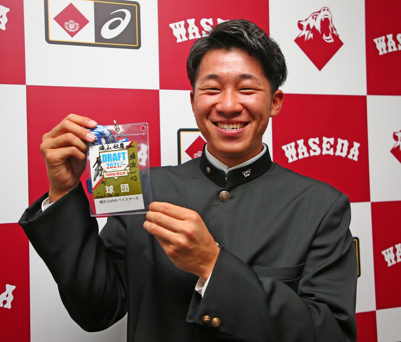 DeNA指名あいさつ　三浦大輔監督のサインの入ったIDパスを手に笑顔のドラフト2位の早大・徳山壮磨（代表撮影）