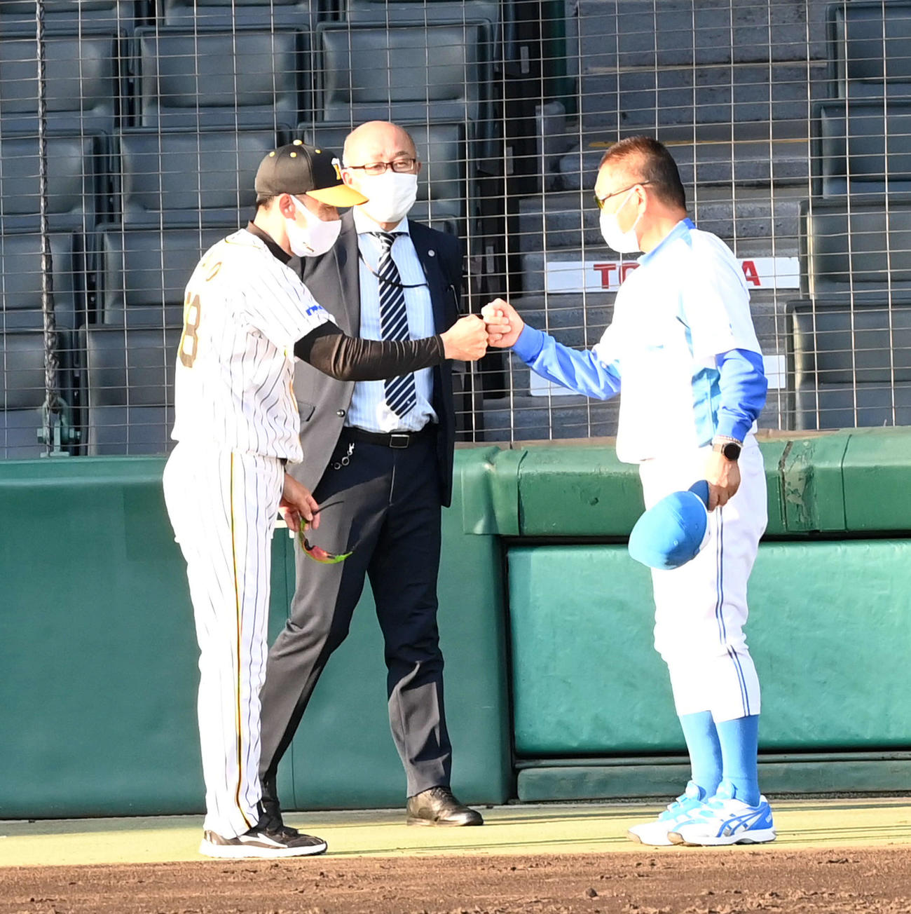 練習試合を終え、大和高田クラブ・佐々木監督（右）とグータッチする阪神矢野監督（撮影・前岡正明）