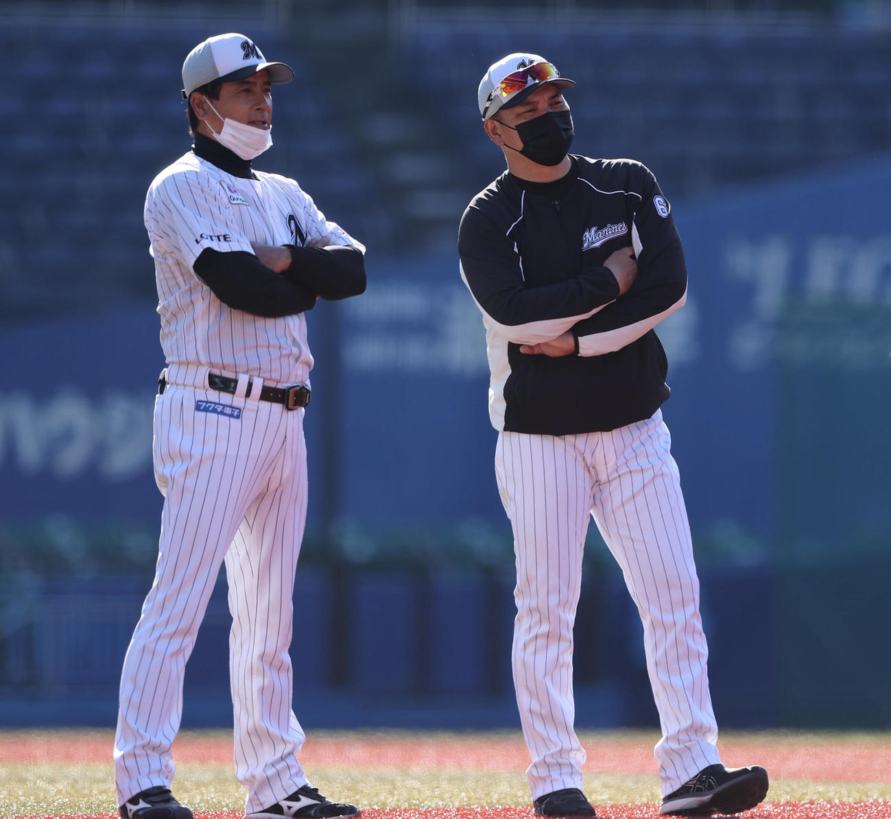 腕を組み森脇コーチ（左）と練習を見つめるロッテ井口監督（撮影・垰建太）