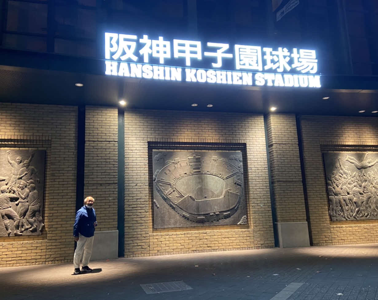 CSファーストステージ開幕日、毎朝の散歩コースの阪神甲子園球場を背に写真に収まる巨人ファンの末吉さん（撮影・小早川宗一郎）
