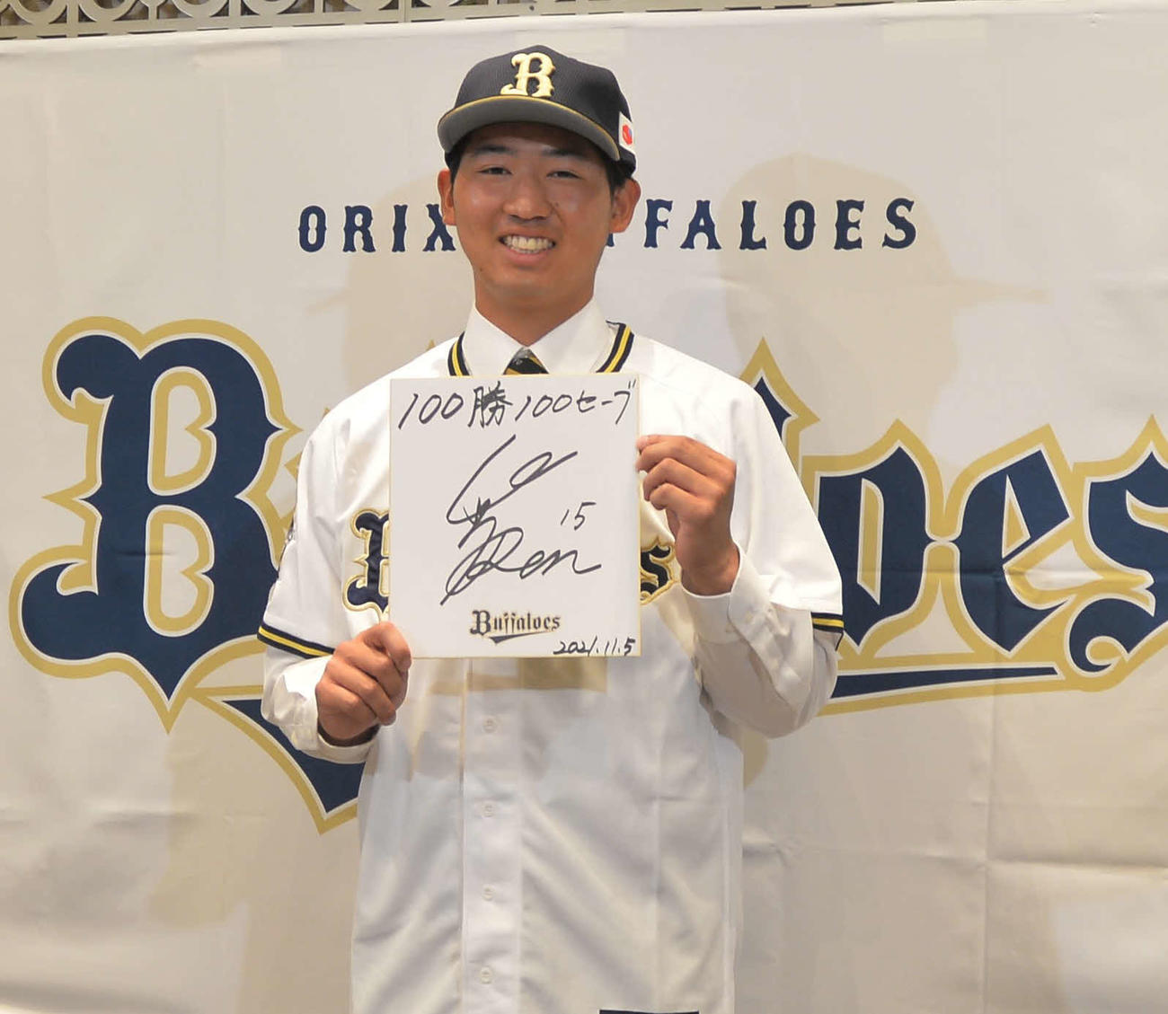 色紙に「100勝100セーブ」を記し、笑顔を見せる東北福祉大・椋木（撮影・佐藤究）