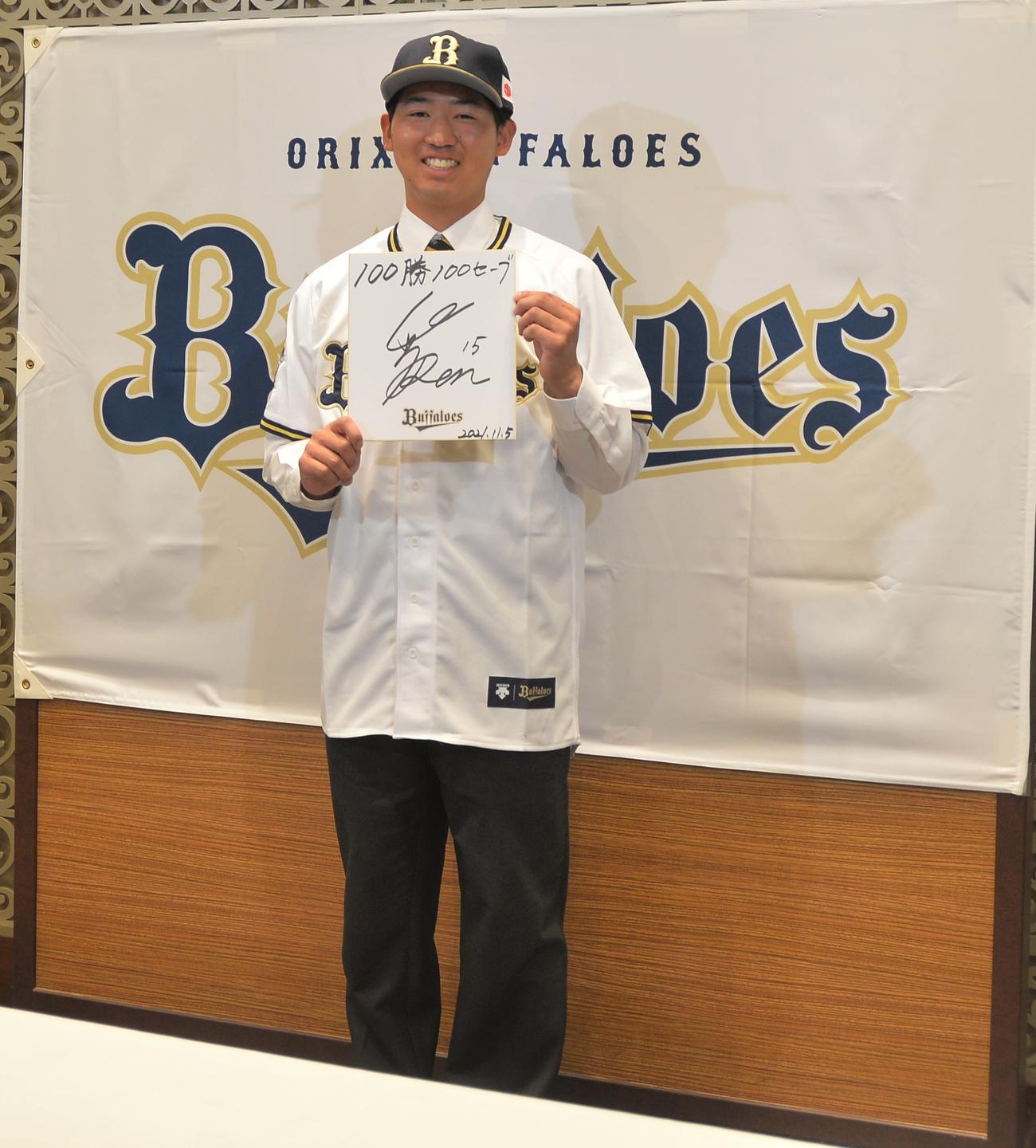 色紙に「100勝100セーブ」を記し、笑顔を見せる東北福祉大・椋木（撮影・佐藤究）