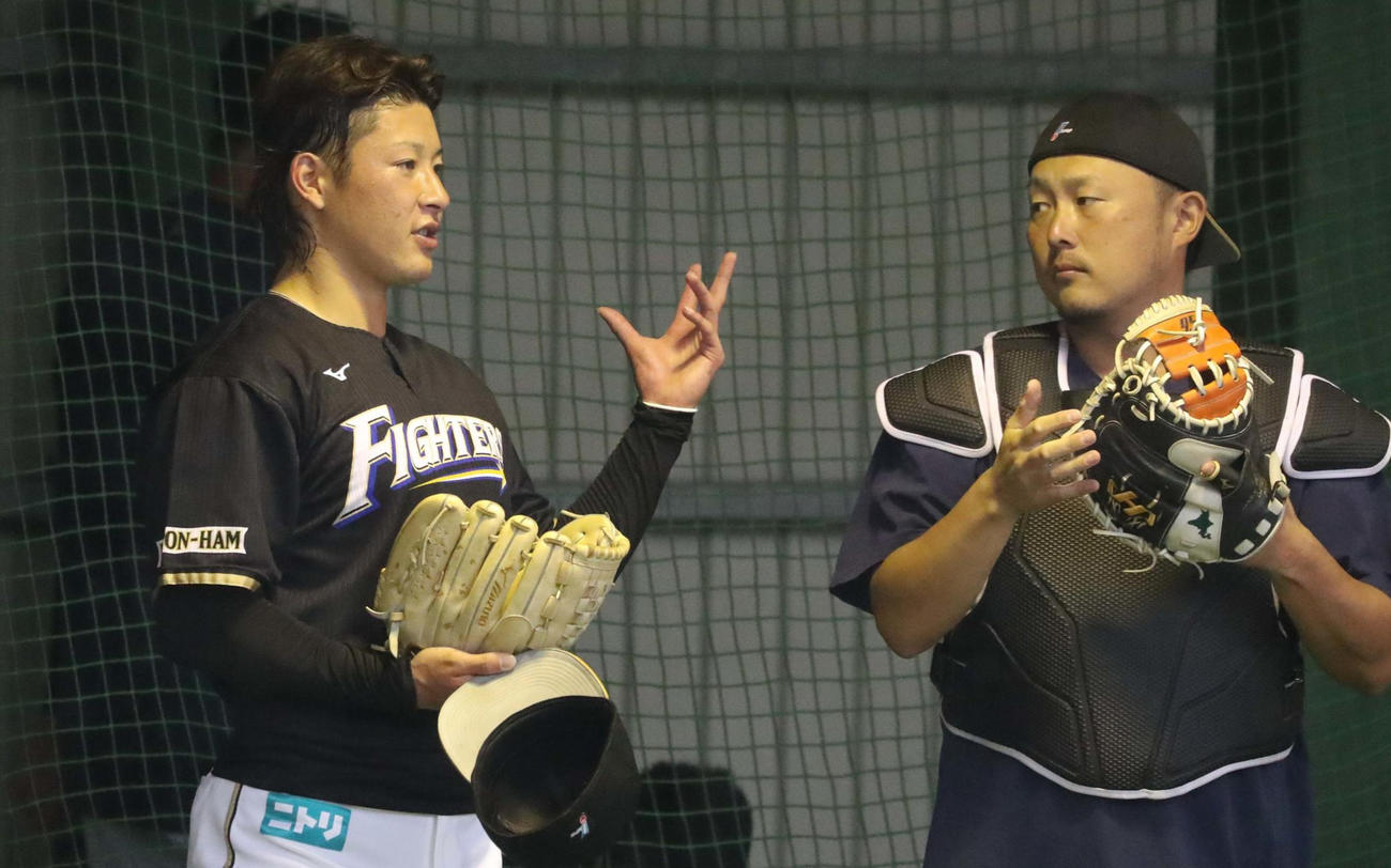 ブルペンで投球後、ブルペン捕手と話す吉田（撮影・黒川智章）