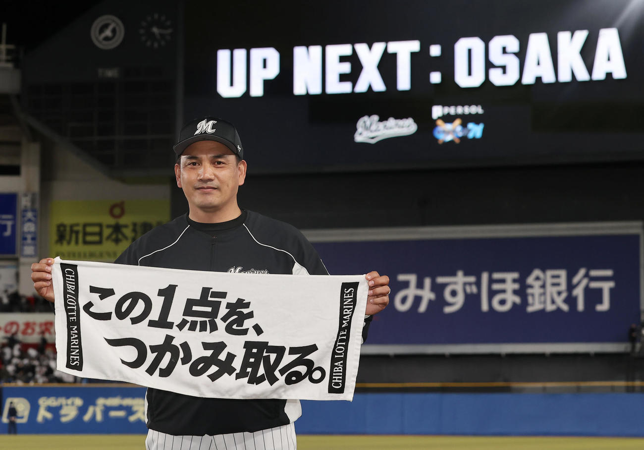 ロッテ対楽天　楽天と引き分けファイナルステージ進出を決めたロッテ井口監督はチームスローガンを手に写真に納まる（撮影・垰建太）
