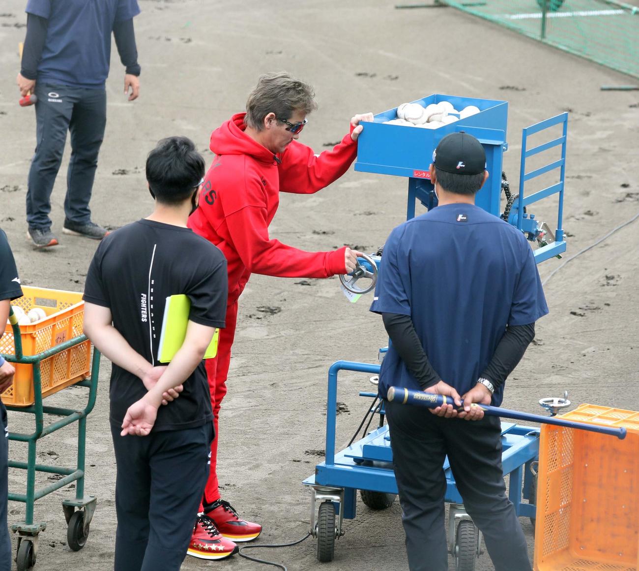 10時54分　バント用マシンの調整をする新庄監督（撮影・黒川智章）