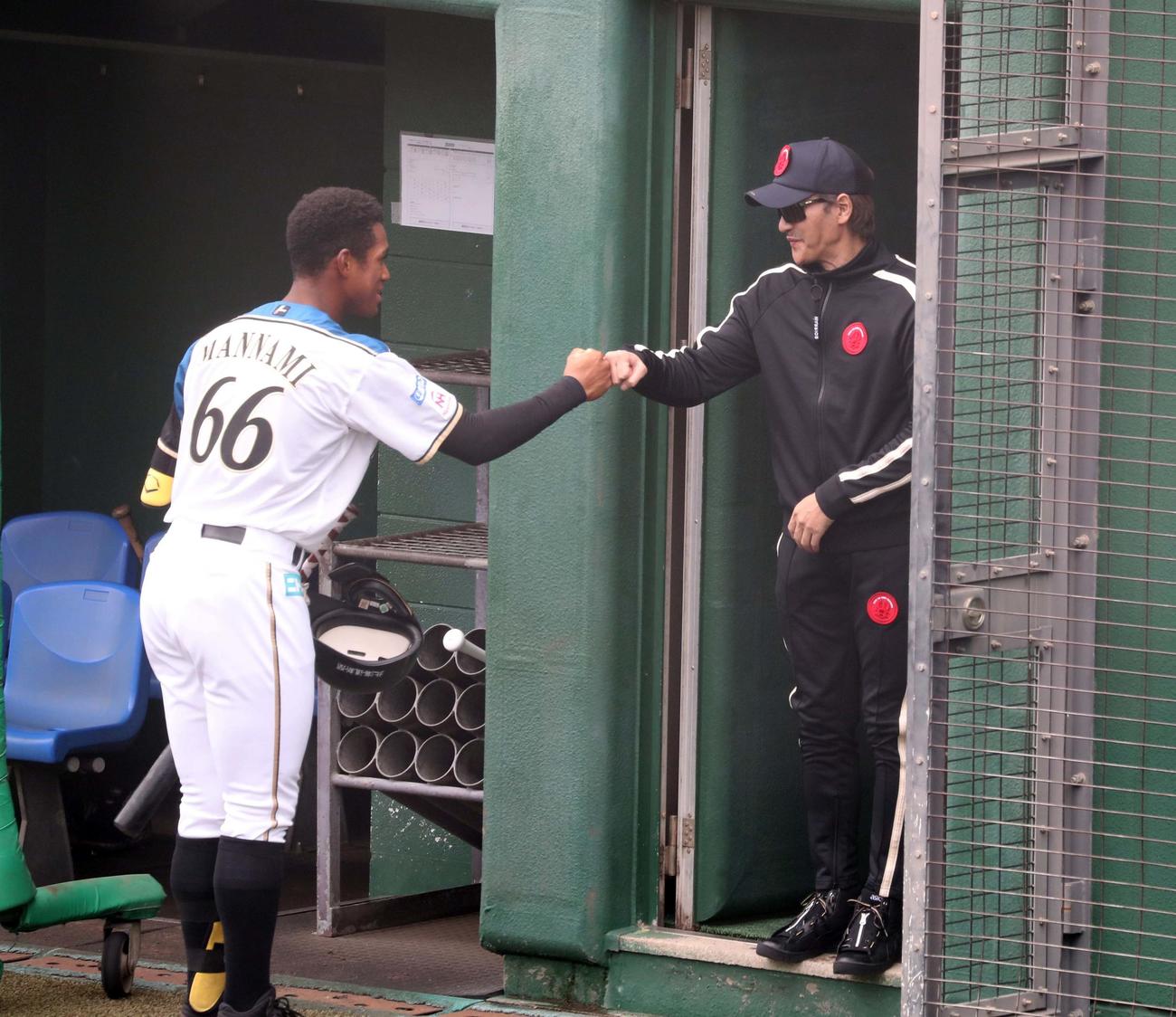 13時35分　黒いジャージに着替えた新庄監督は万波とタッチする（撮影・黒川智章）