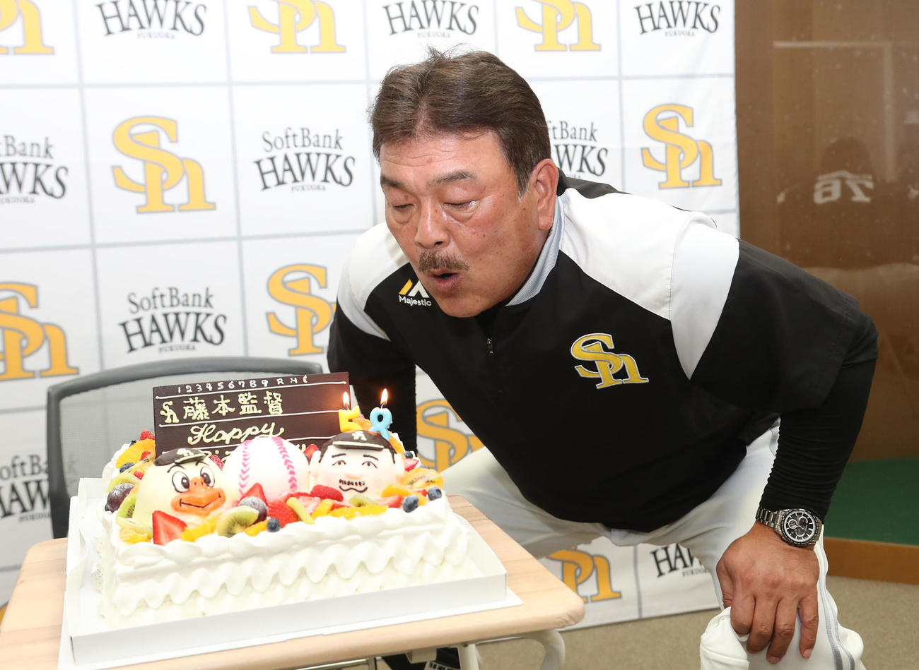 今月8日で58歳を迎えた藤本博史監督はバースデーケーキを前に記念撮影、ろうそくの火を吹き消す（撮影・梅根麻紀）