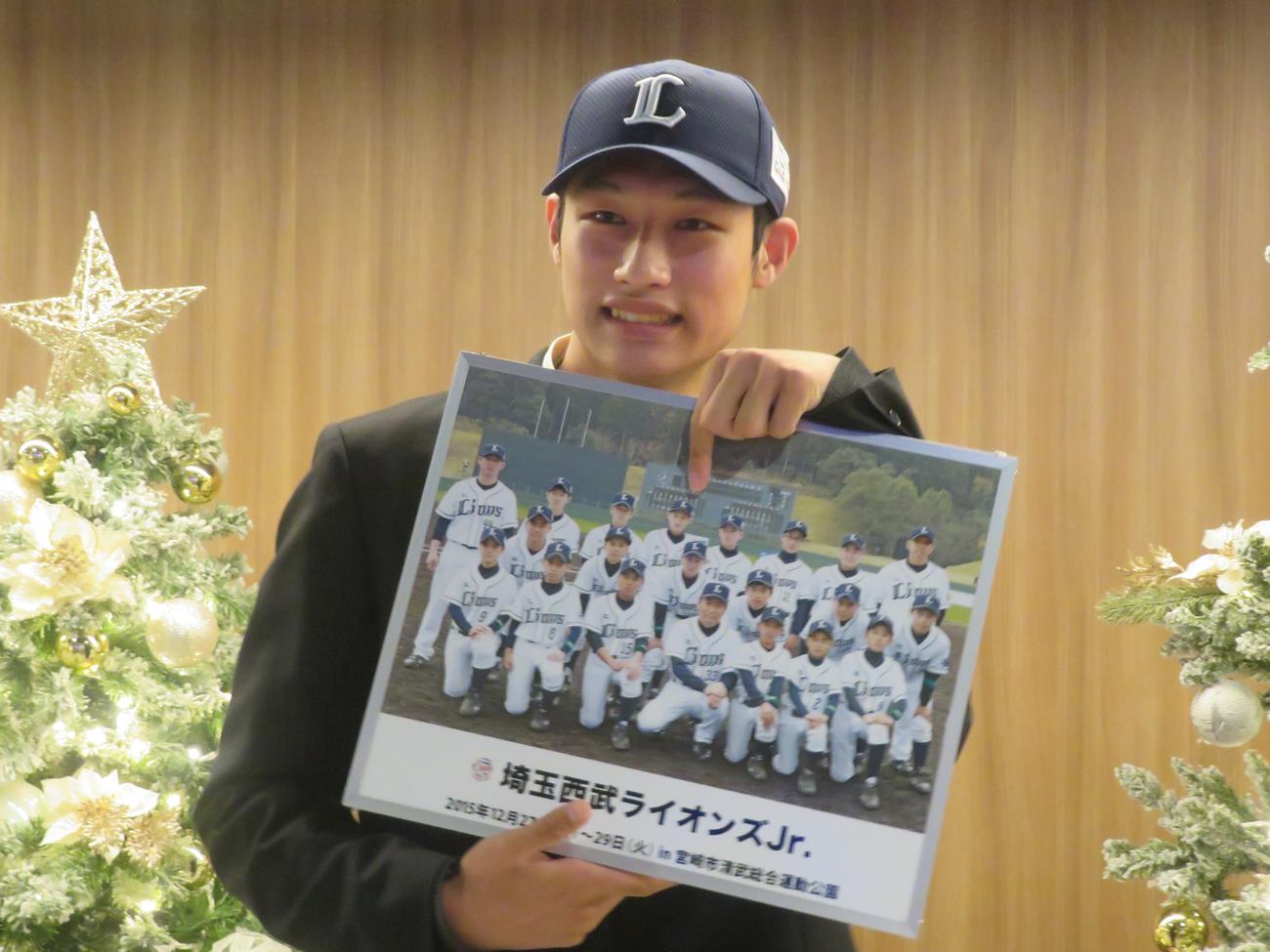 西武ドラフト４位の八王子学園八王子・羽田は仮契約を終え、笑顔でライオンズジュニア時代の自身を指さす（撮影・上田悠太）