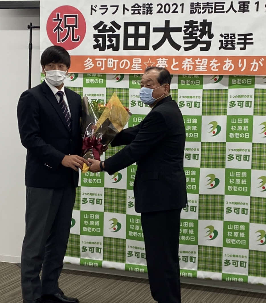 兵庫・多可町役場を表敬訪問した巨人ドラフト1位の関西国際大・翁田（左）に花束を手渡す吉田町長（撮影・小早川宗一郎）