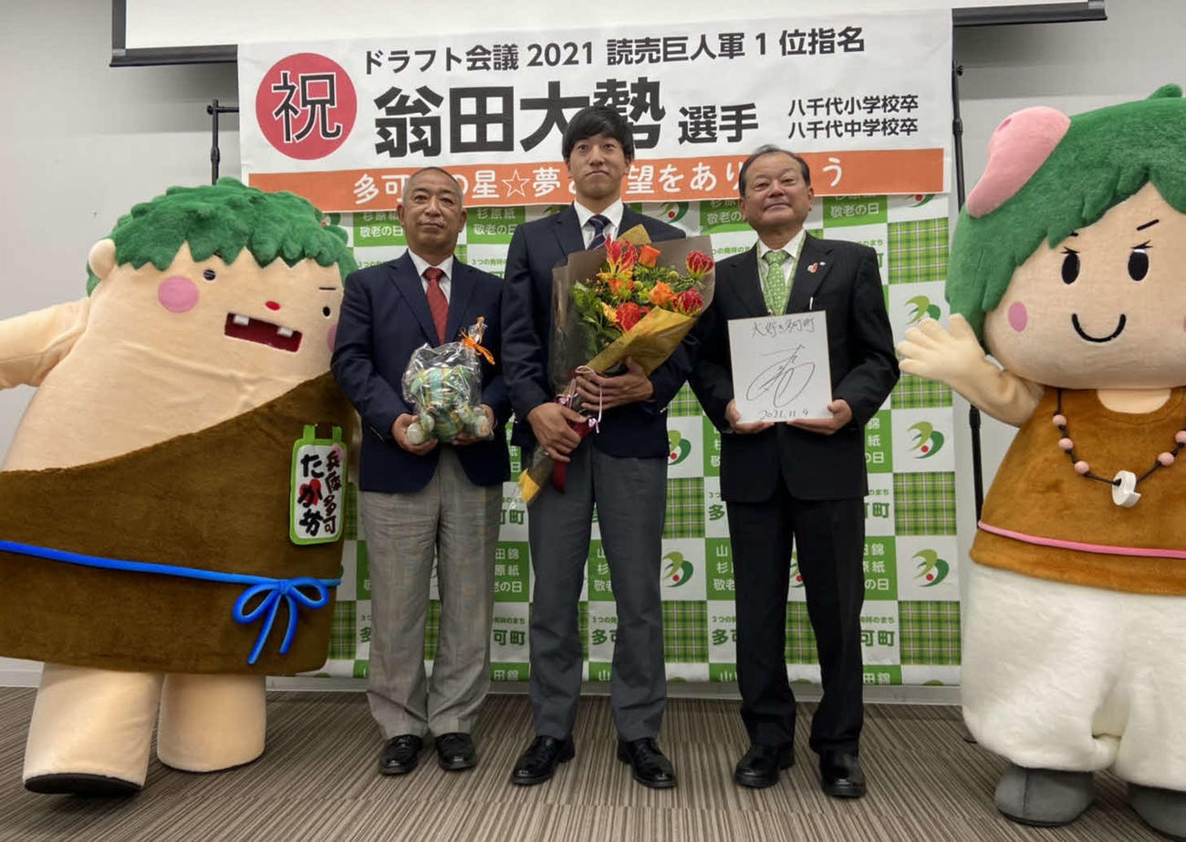 兵庫・多可町役場を表敬訪問した巨人ドラフト1位の関西国際大・翁田は、同大の鈴木監督（左から2番目）、同町の吉田町長（右から2番目）、ゆるキャラ「たか坊（左）」と「ふう子（右）」と記念撮影（撮影・小早川宗一郎）