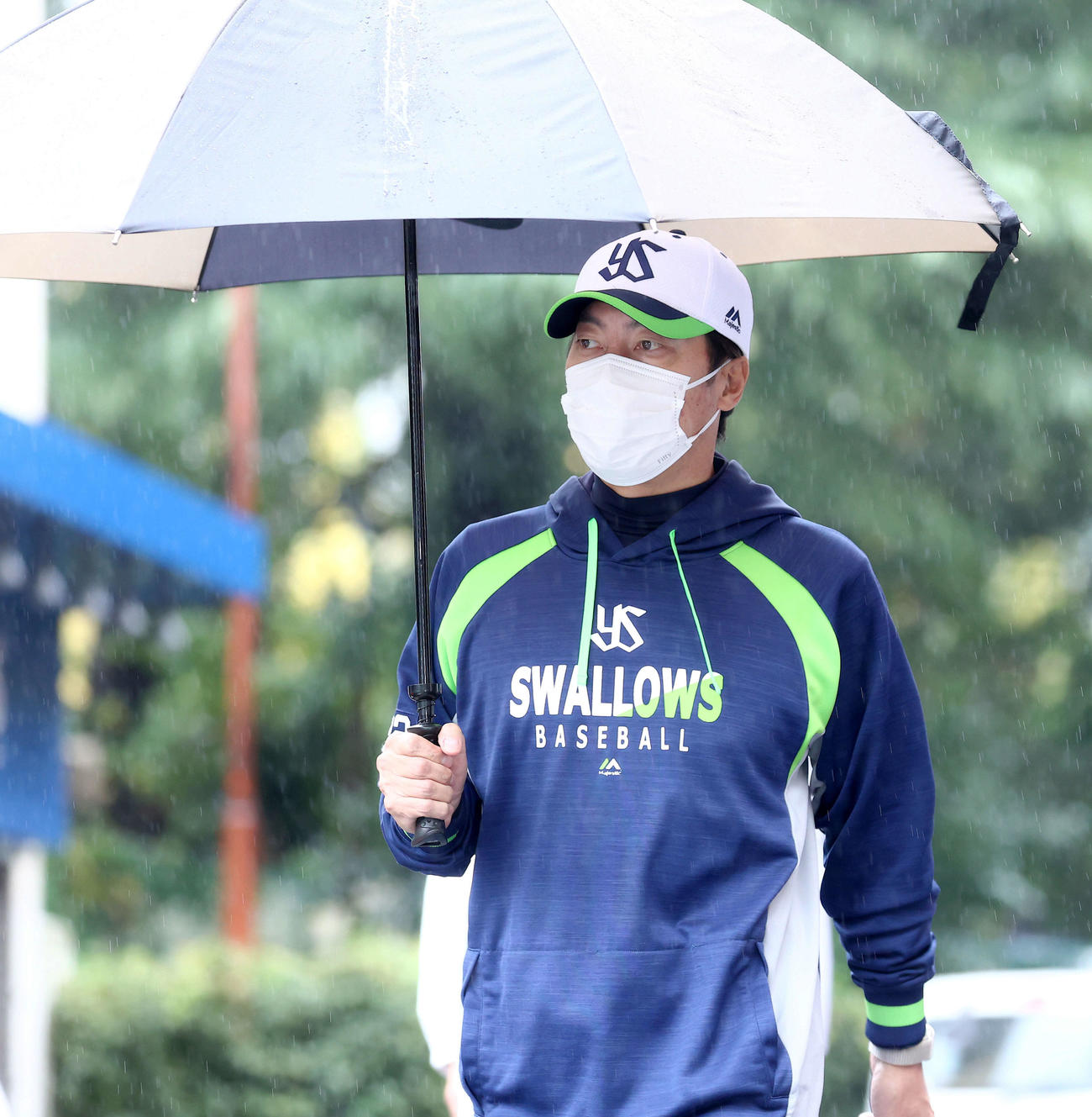 傘を差し室内練習場に向かうヤクルト高津監督（撮影・河田真司）
