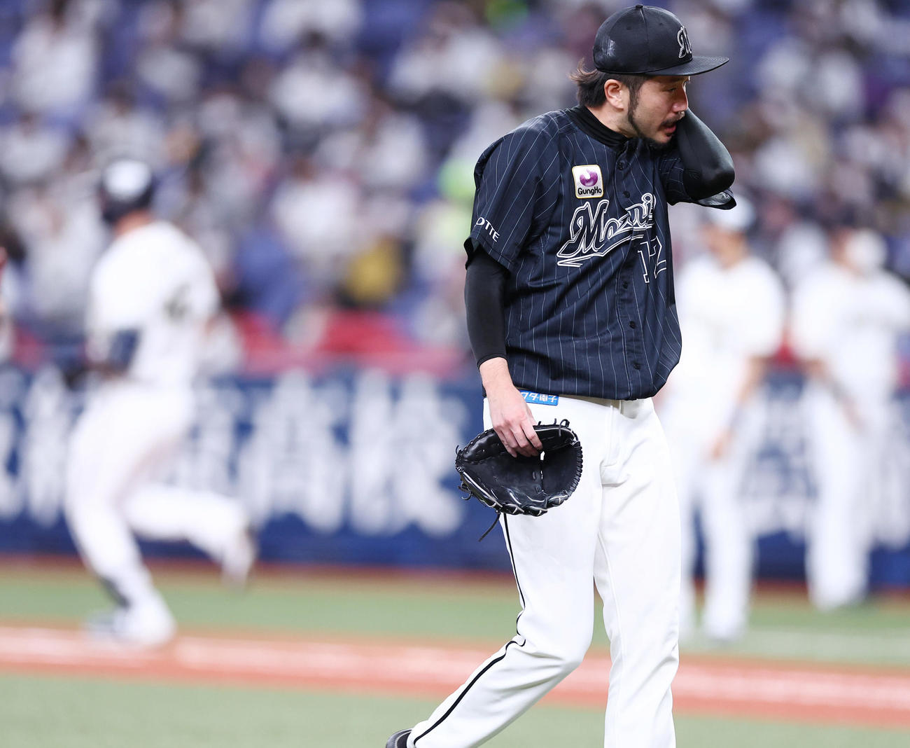 オリックス対ロッテ　1回裏の登板を終え先制を許したロッテ先発の石川は汗をぬぐいながら引き揚げる（撮影・垰建太）