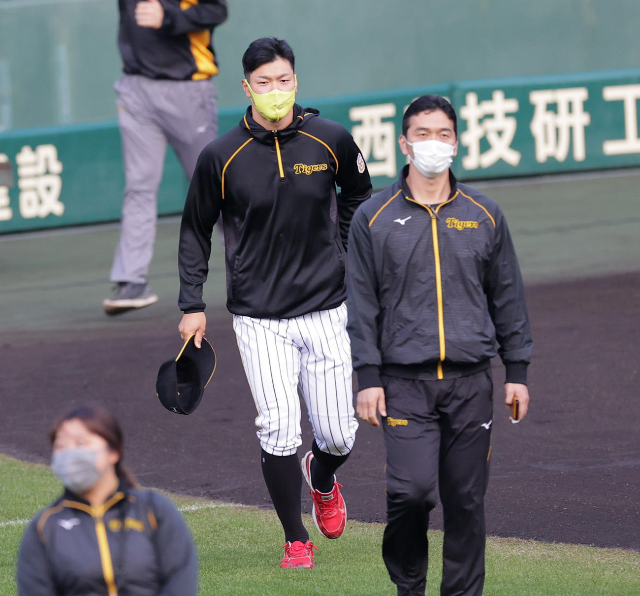 練習前の円陣に加わりにいく阪神佐藤輝（撮影・清水貴仁）