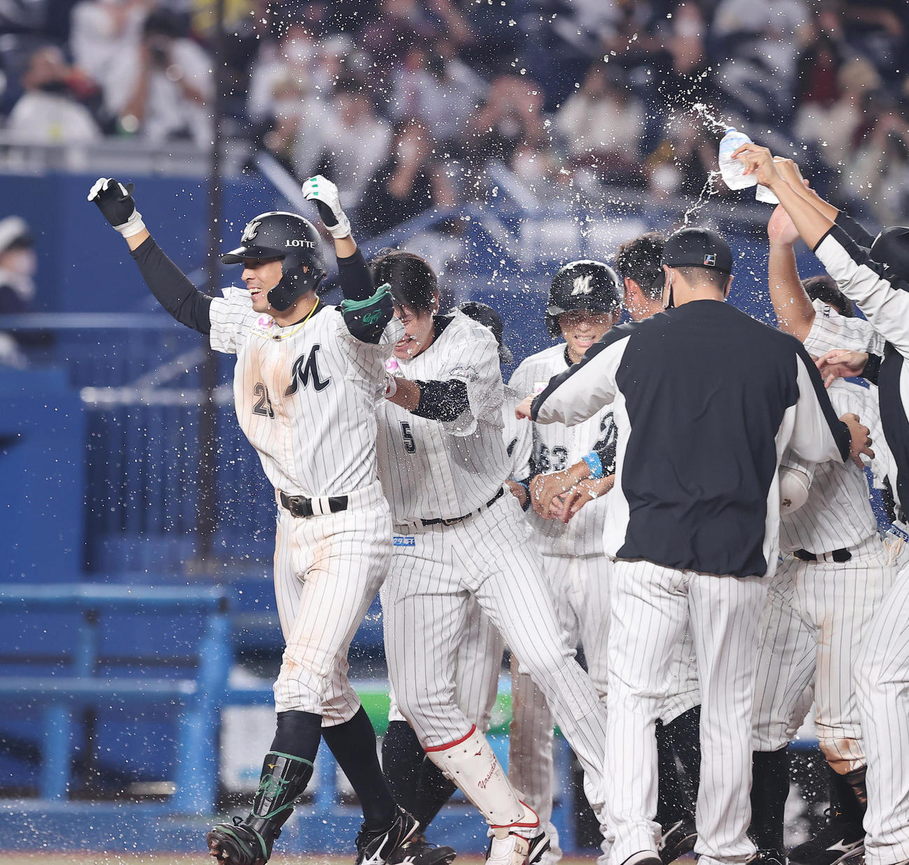 ロッテ対ソフトバンク　9回裏ロッテ2死一塁、サヨナラ2点本塁打を放ちナインの出迎えを受ける岡（左）（2021年10月15日撮影）